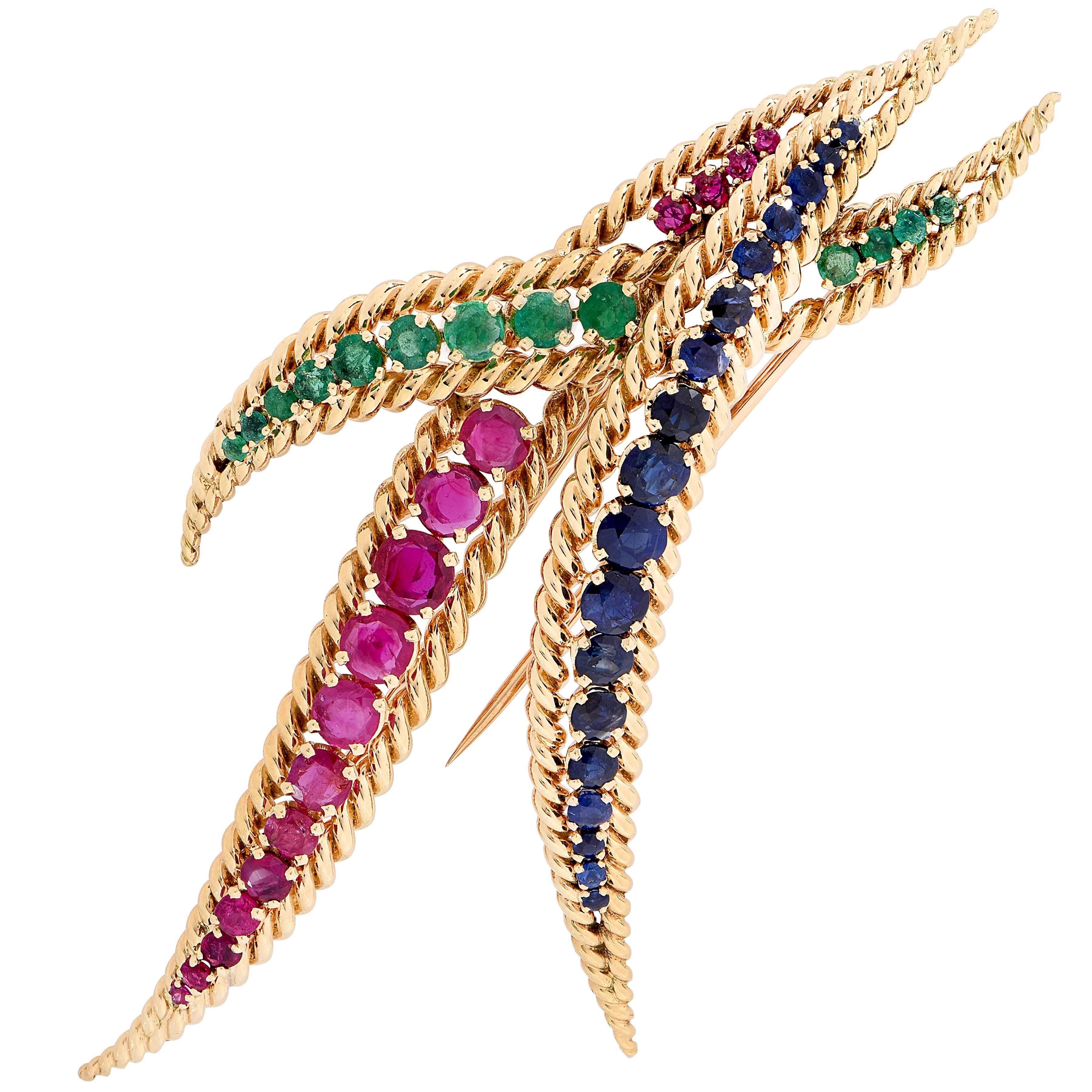 Large Mauboussin brooch set with 13 emeralds weighing approximately 1 carat, 18 sapphires weighing approximately 3 carats and 16 rubies weighing approximately 3.50 carats. Numbered and signed Mauboussin Paris. 

Metal Type: 18Kt Yellow Gold
Metal
