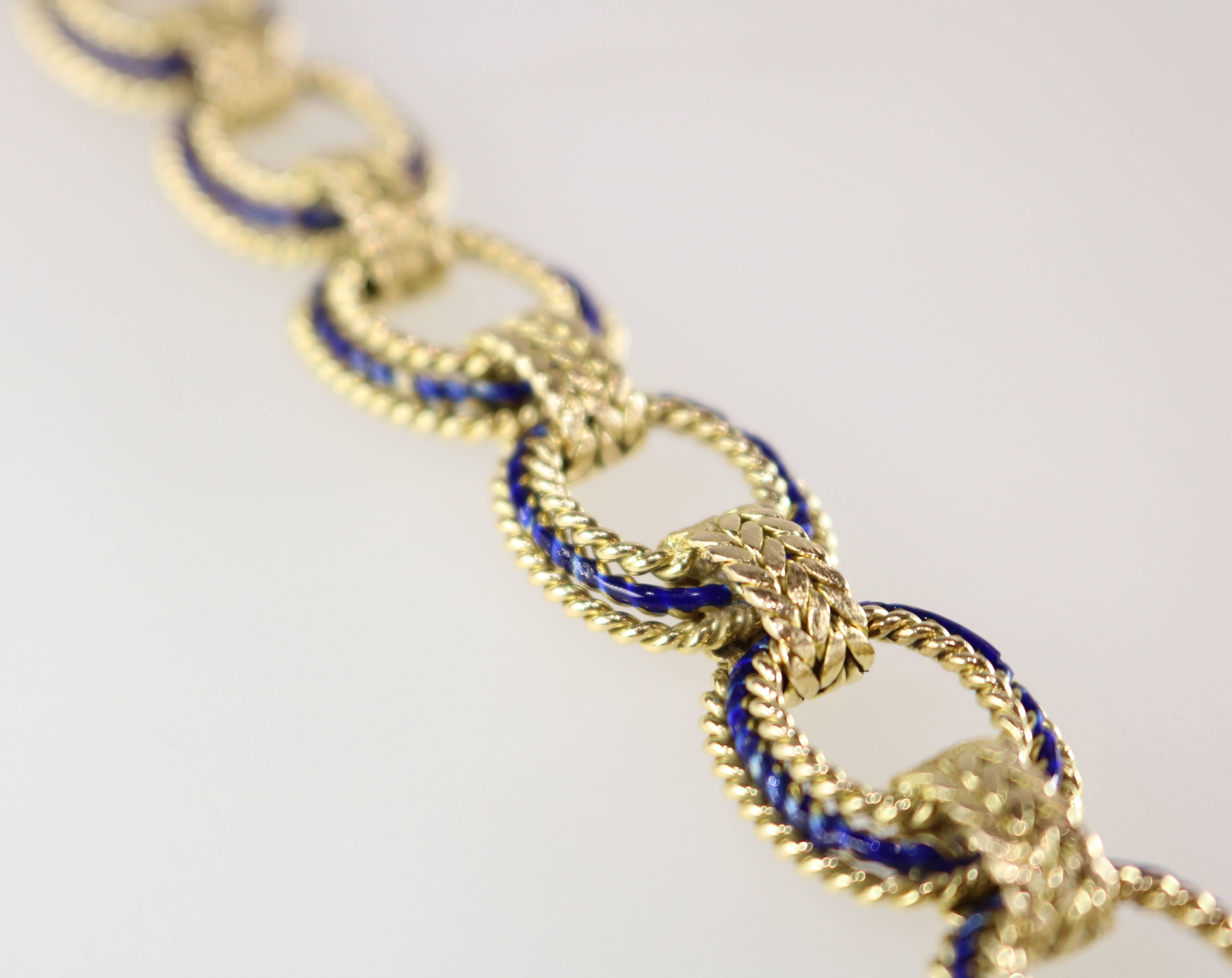 This very pretty bracelet consists of a series of tiered corded wire work oval links with applied blue enamel and herringbone textured connections.
Bracelet length is 7 3/4 inches.

Metal Type: 18 Karat Yellow Gold.