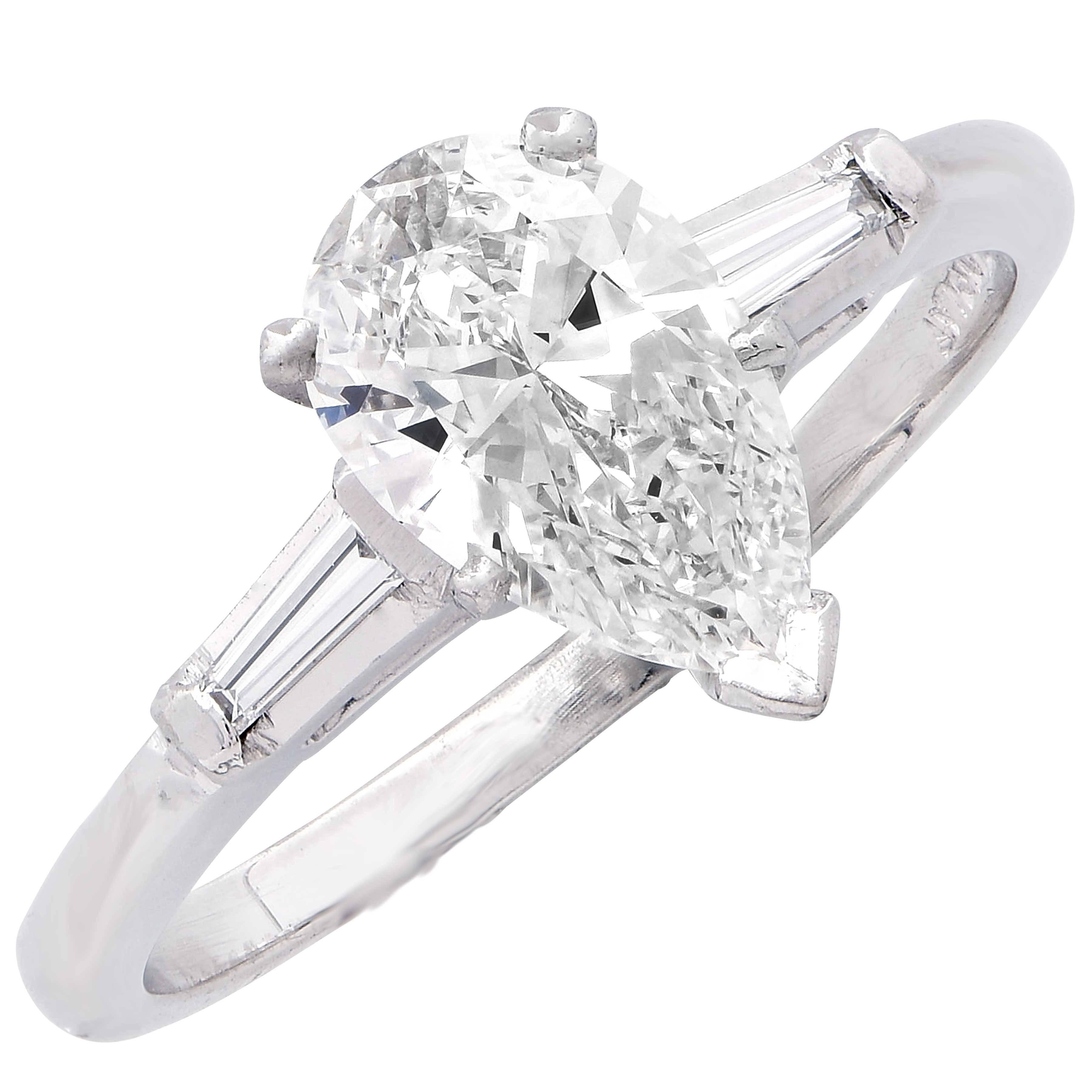 Diamond engagement ring set with a pear shape diamond weighing 1.04 carats. The diamond is GIA certified, color-G and clarity VS1. The platinum mounting is further set with 2 small tapered baguettes. Size 6. Can be sized with no additional charge. 