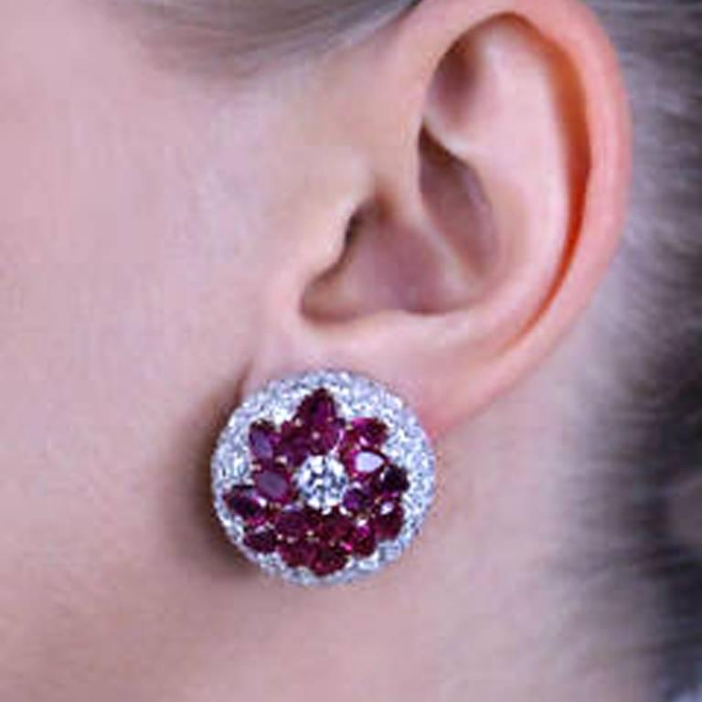 These magnificent Burmese Ruby and Diamond earrings feature approximately 12 carats of pear shaped vibrant red rubies surrounded by 9 carats of fine quality diamonds E/F color and VS/SI clarity set in platinum with 18 karat white and yellow gold