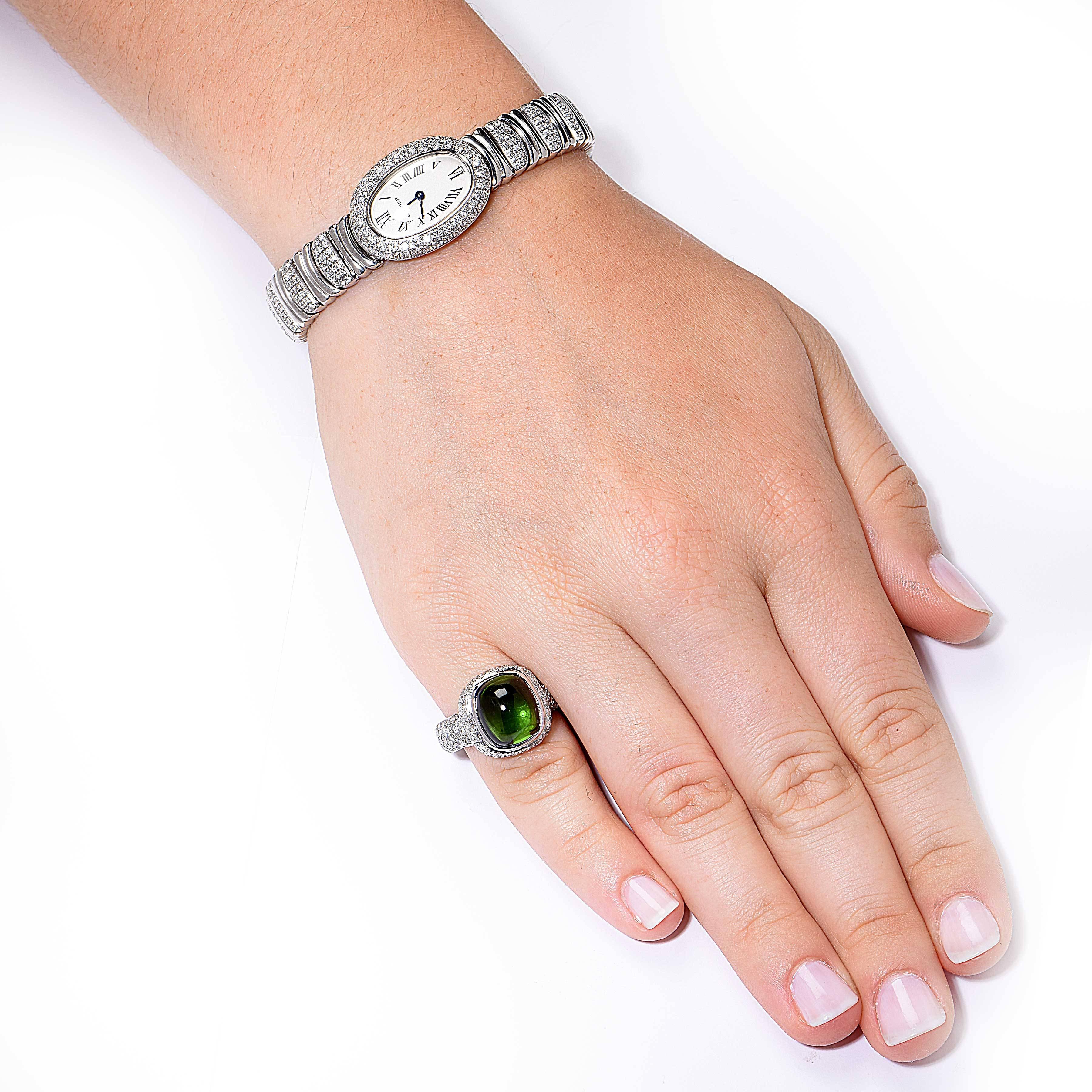 This gorgeous modern design natural green cabochon cut tourmaline and diamond ring features a 6.15 carat rich and inviting natural green tourmaline surrounded by approximately 2 carats of round brilliant cut diamonds set in 18 Karat White