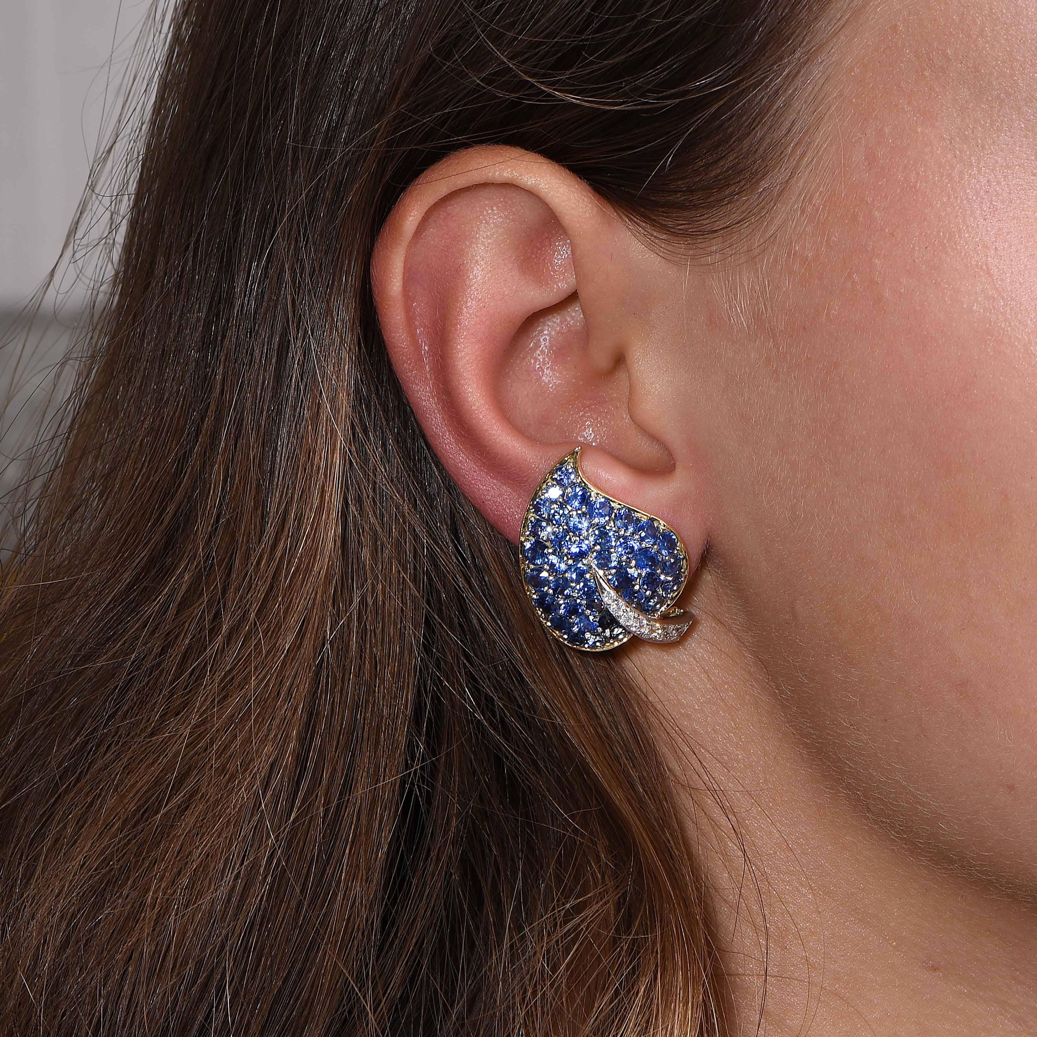 Sapphire and Diamond Van Cleef and Arpels leaf design earrings featuring 56 round cut blue sapphires with an estimated total weight of 5.6 carats and 14 transitional cut diamonds with an estimated total weight of .45 carats set in 18 karat yellow