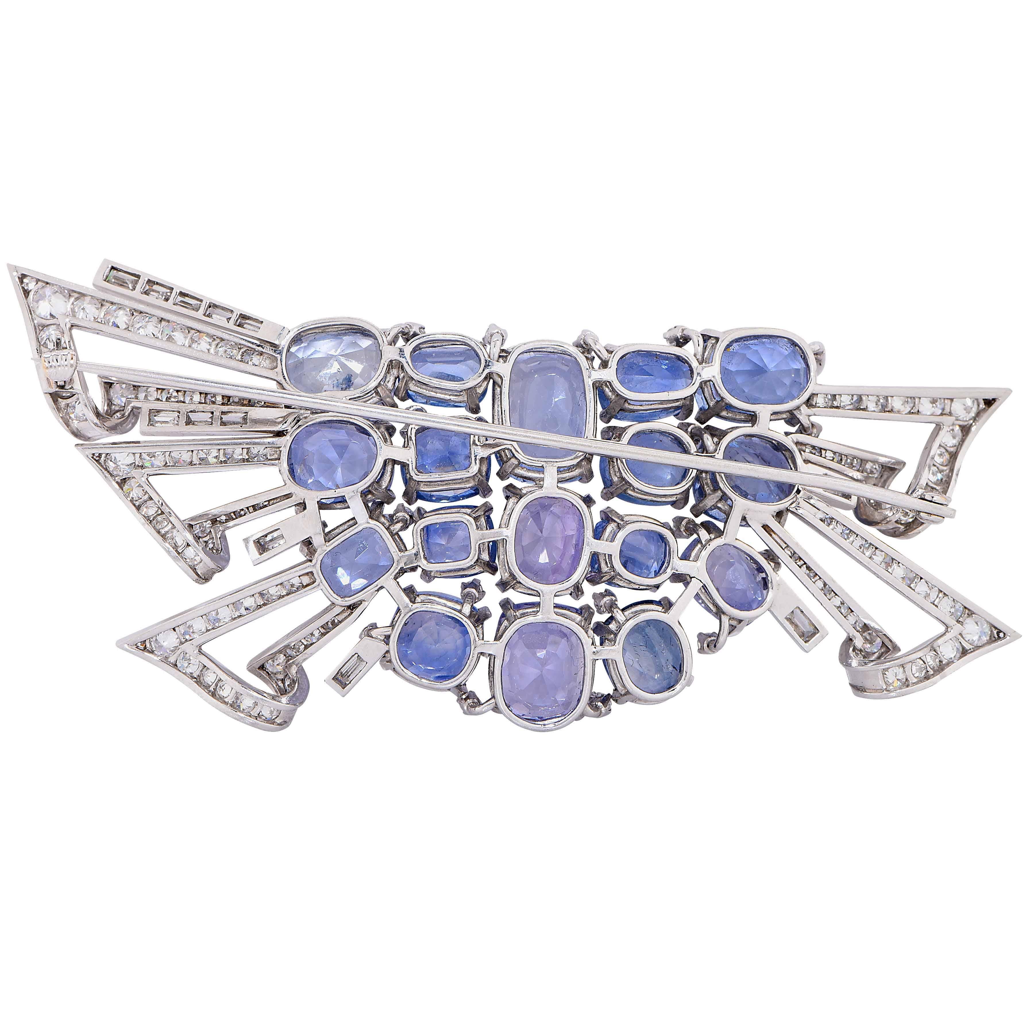 Mid Century Design Blue and Purple Sapphire and Diamond Platinum Brooch featuring 17 cushion and oval cut blue and purple natural sapphires with an estimated total weight of 50 carats and round cut diamonds with an estimated total weight of 5 carats