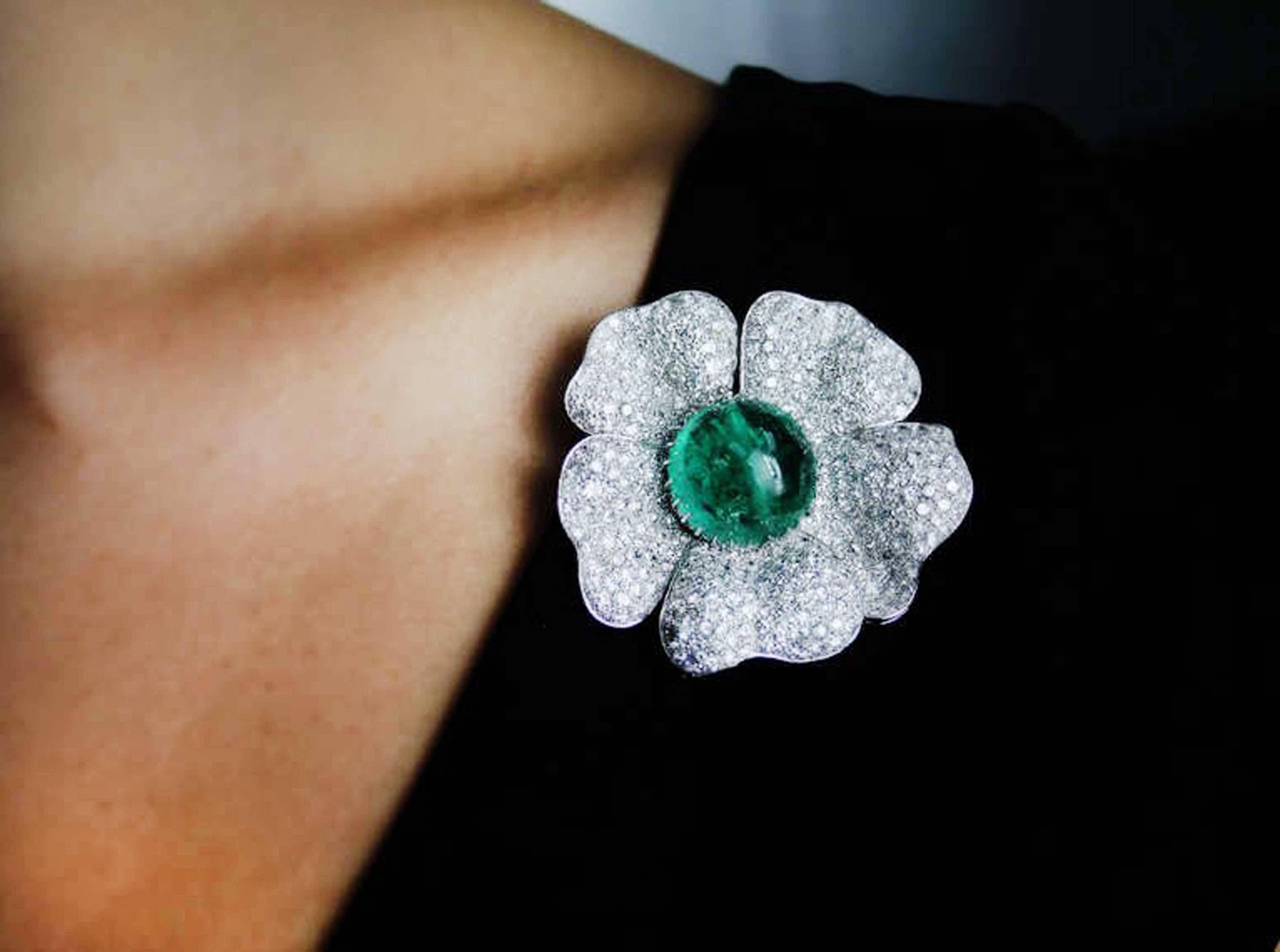This stunning platinum brooch features a natural cabochon cut emerald weighing 33.93 carats set in a flower motif brooch which has 340 bead set round brilliant cut diamonds with an estimated total weight of 15 carats.

This brooch was owned by the
