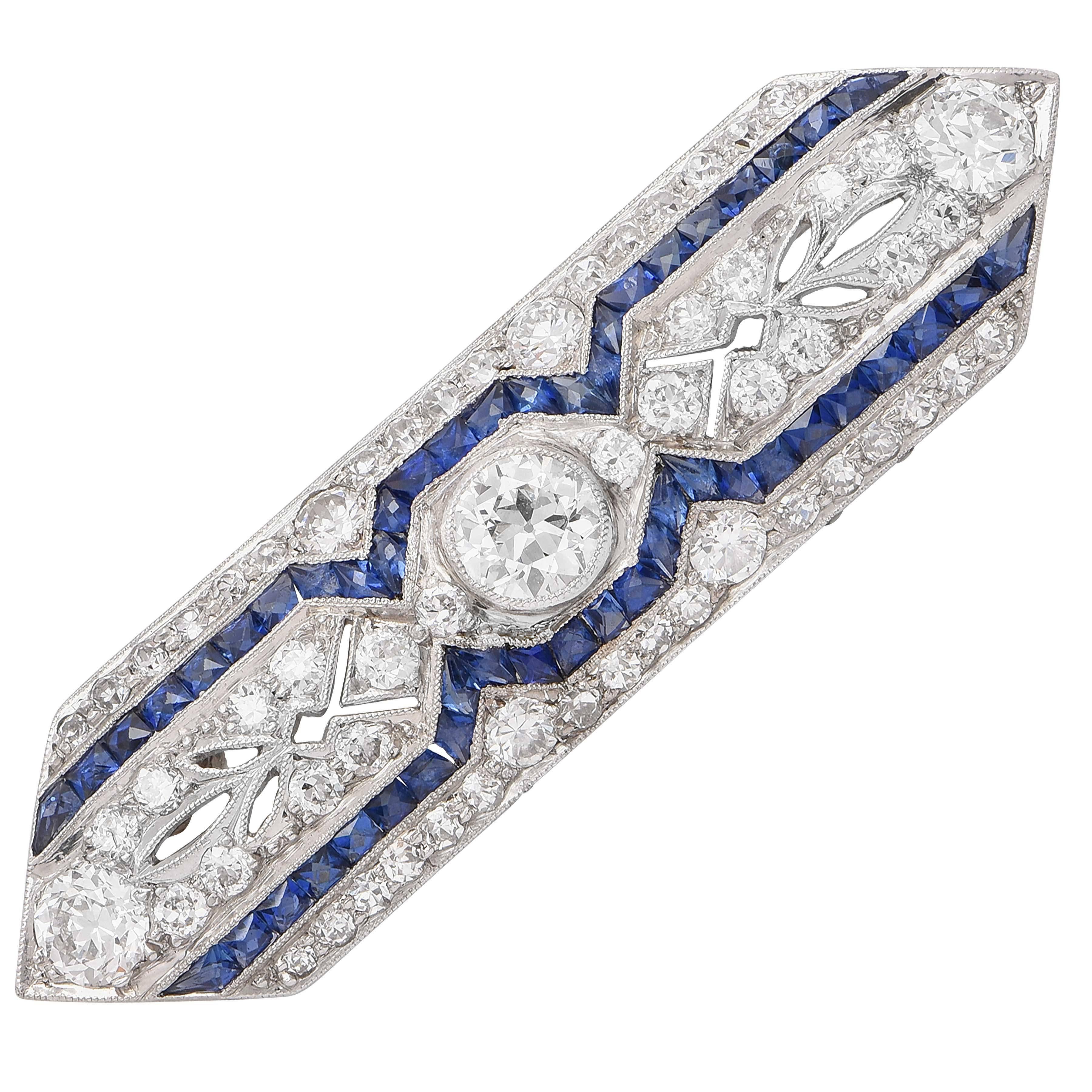 Art deco platinum, sapphire and diamond brooch bezel set with and old european cut diamond and set throughout with old european and old single cut diamonds with an with millegrain accents weighing approximately 2.10 carats and 2 rows of calibre-cut