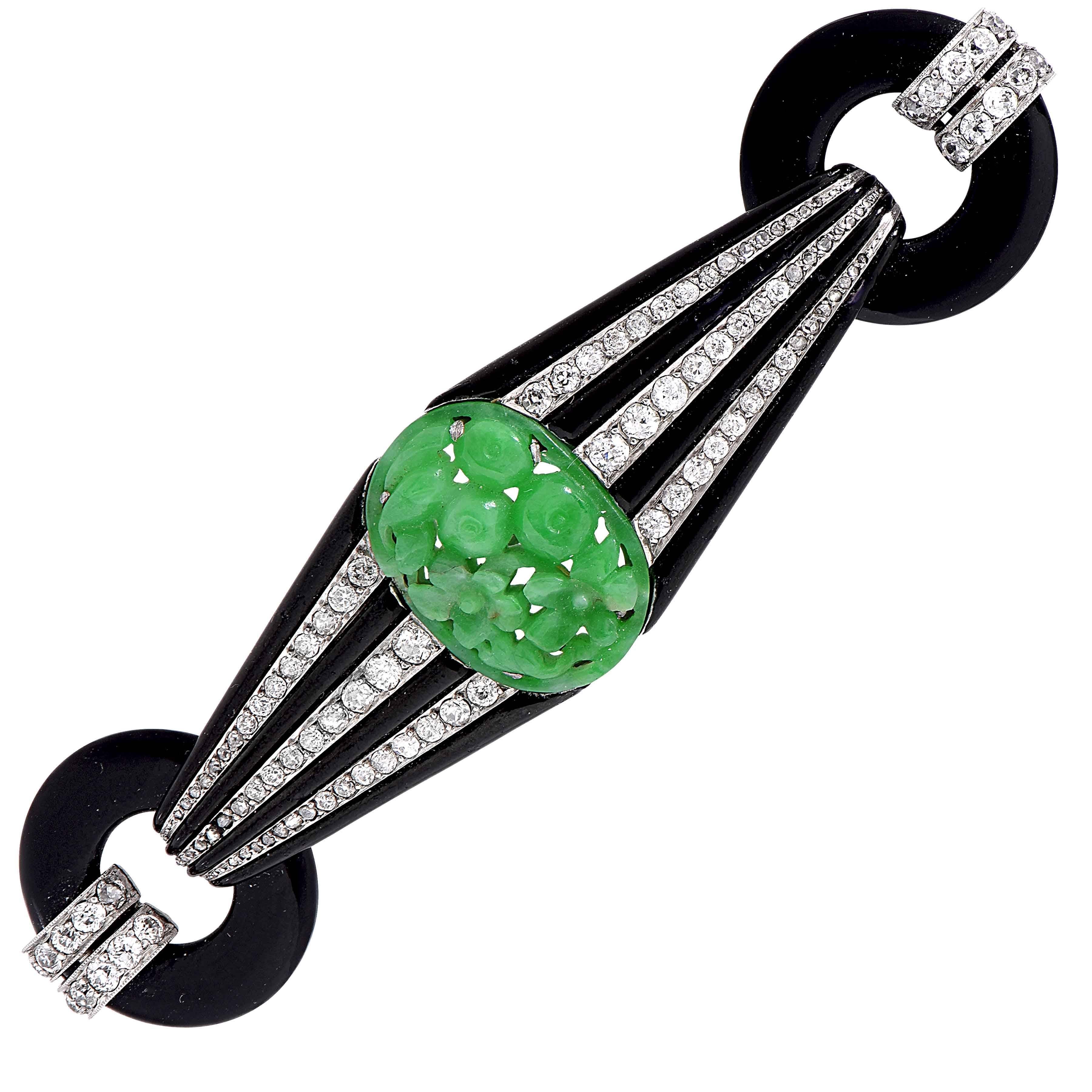 French Art deco brooch set with rose cut and old mine cut diamonds. The  center of the brooch is set with carved jade, with diamonds and enamel tapering down to the two round onyx ends.

Metal Type: Platinum
Metal Weight: 20.8 Grams