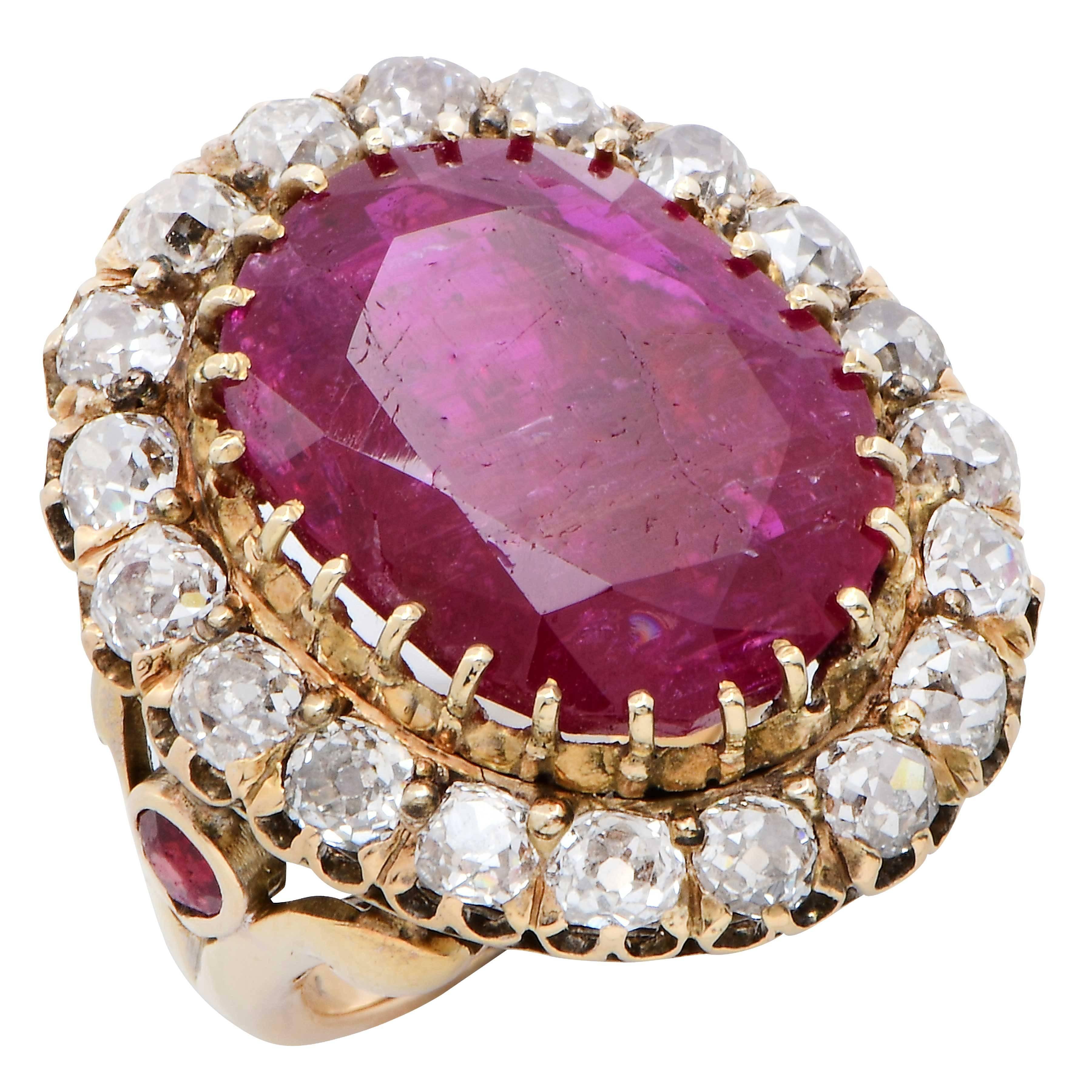 Ruby ring set with an oval ruby weighing approximately 12 carats, and 2 pear shape rubies weighing approximately 0.50 carats. The oval ruby is surrounding with approximately 3 carats of old mine cut diamonds. Size 4 1/2. Can be sized.