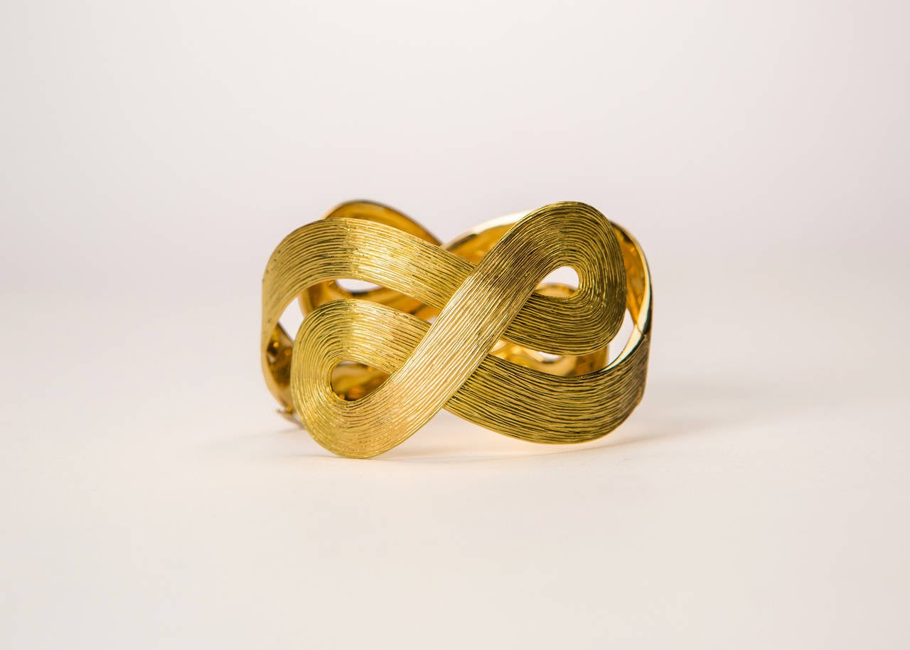 A beautiful dramatic textured 18k gold bangle bracelet created by H Stern. Approximately 1 1/2 inches wide. Simply wearable art !!!
