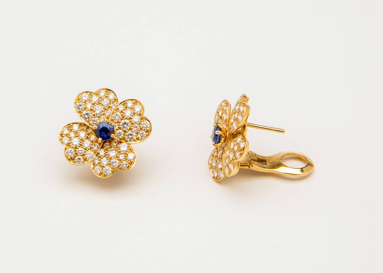 Simply Classic and Iconic. Van Cleef & Arpels yellow gold and diamond medium size Cosmos earrings with a center sapphire. 3/4 inch diameter