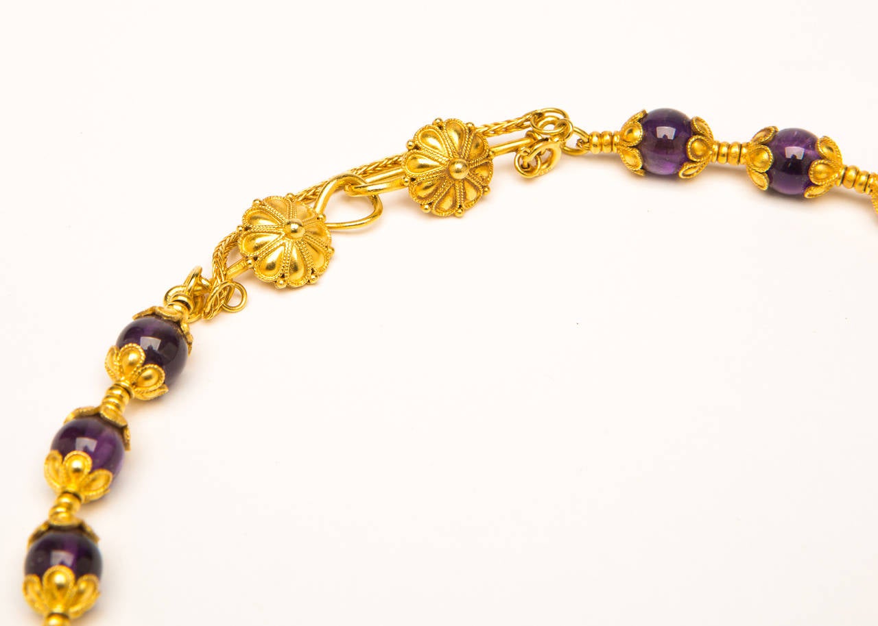 The signature design and detailing of Ilias Lalaounis cradles each vivid purple amethyst bead and beautiful decorative clasp. 17 inches in length. the amethyst beads measure 8 mm