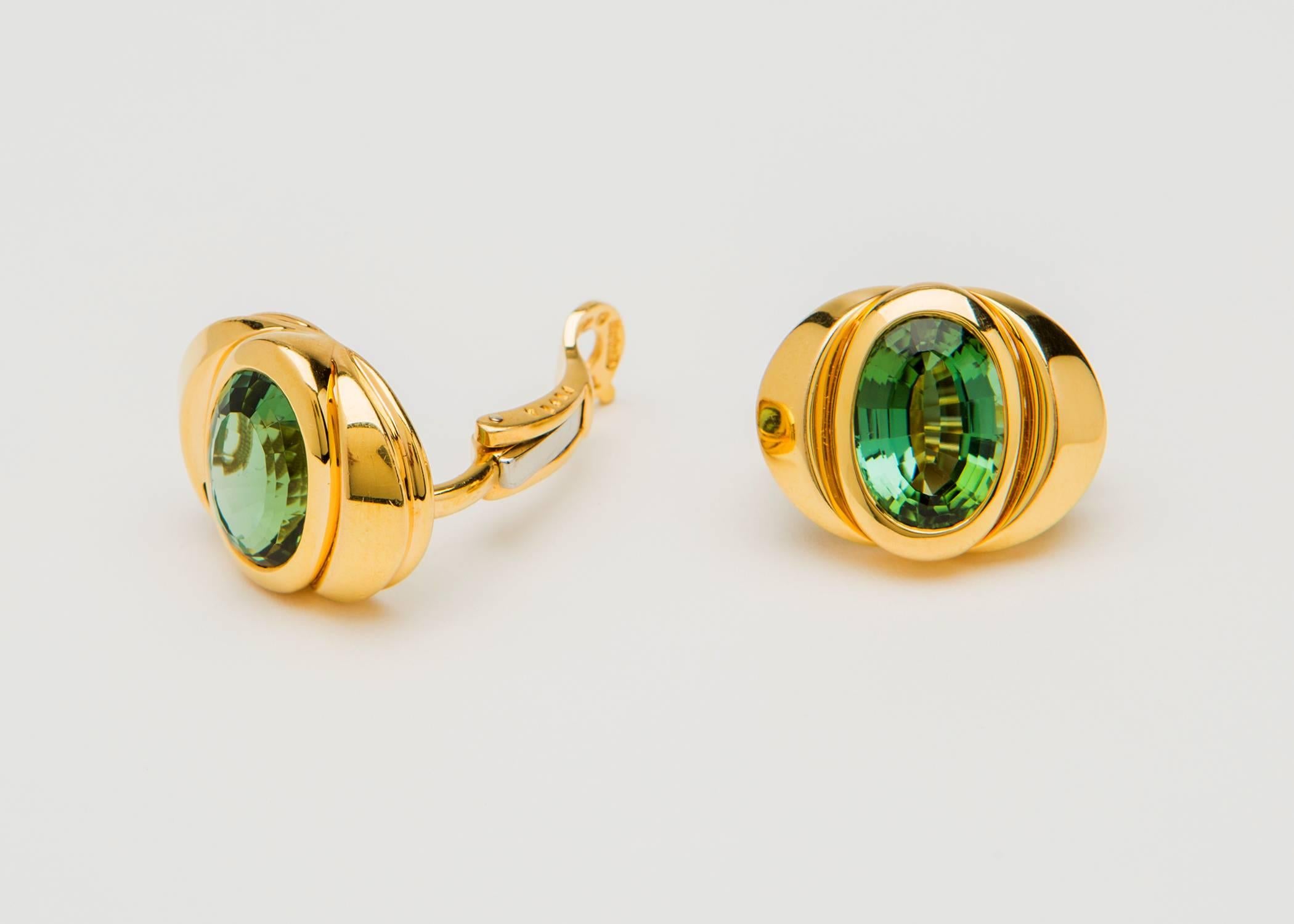 This is an extremely fine matched pair of green tourmalines. They exhibit great saturation of color and excellent cutting. The Iconic designer Marina B has set them in simple mountings with dramatic architectural shape and lines. Please view the