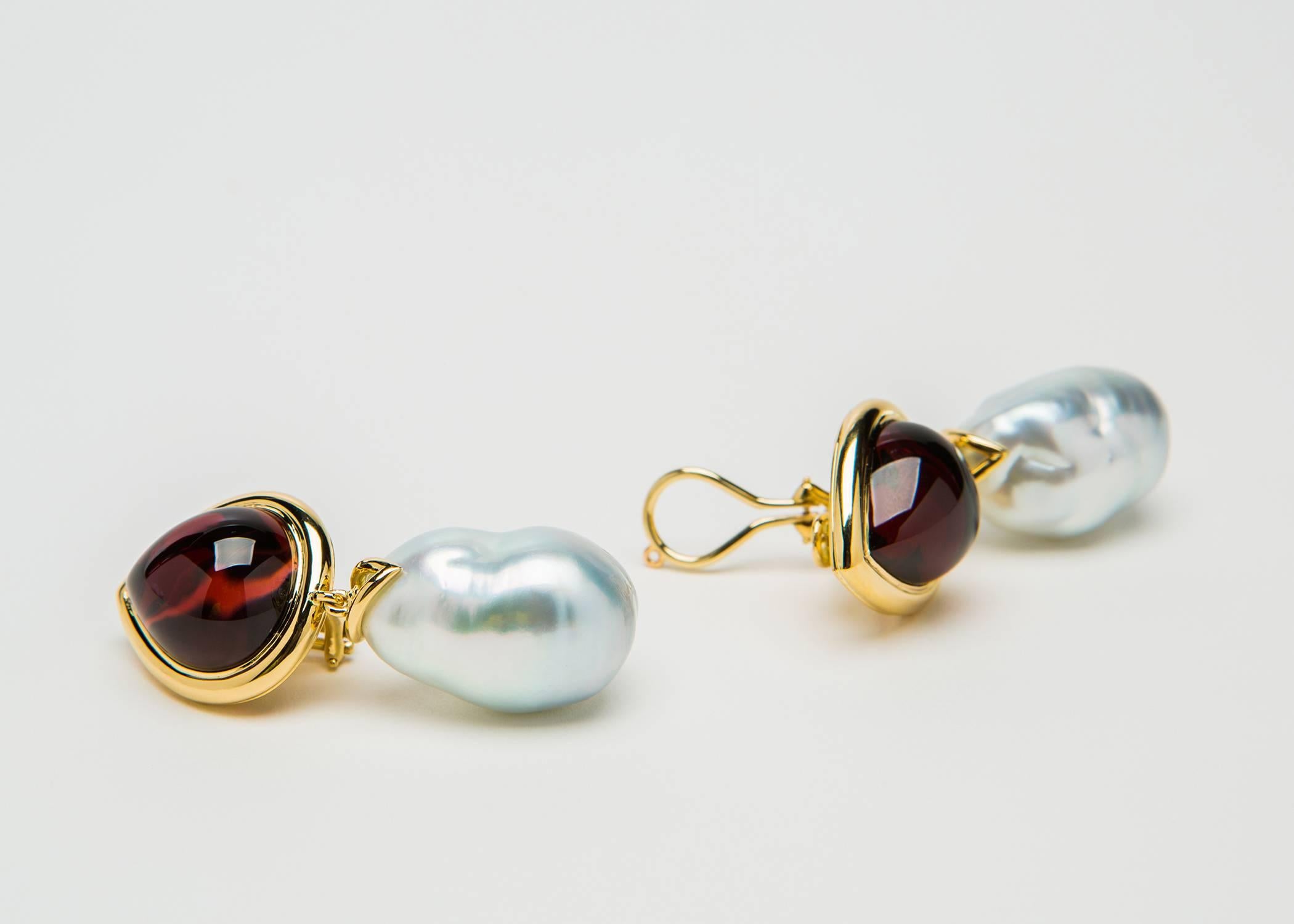 The importance of this pair of earrings is not just the the rare size but the extraordinary quality of these gemstones. The deep richness of this pair of cabochon garnets is brought out by exceptional German cutting. Each stone is 20 carats in
