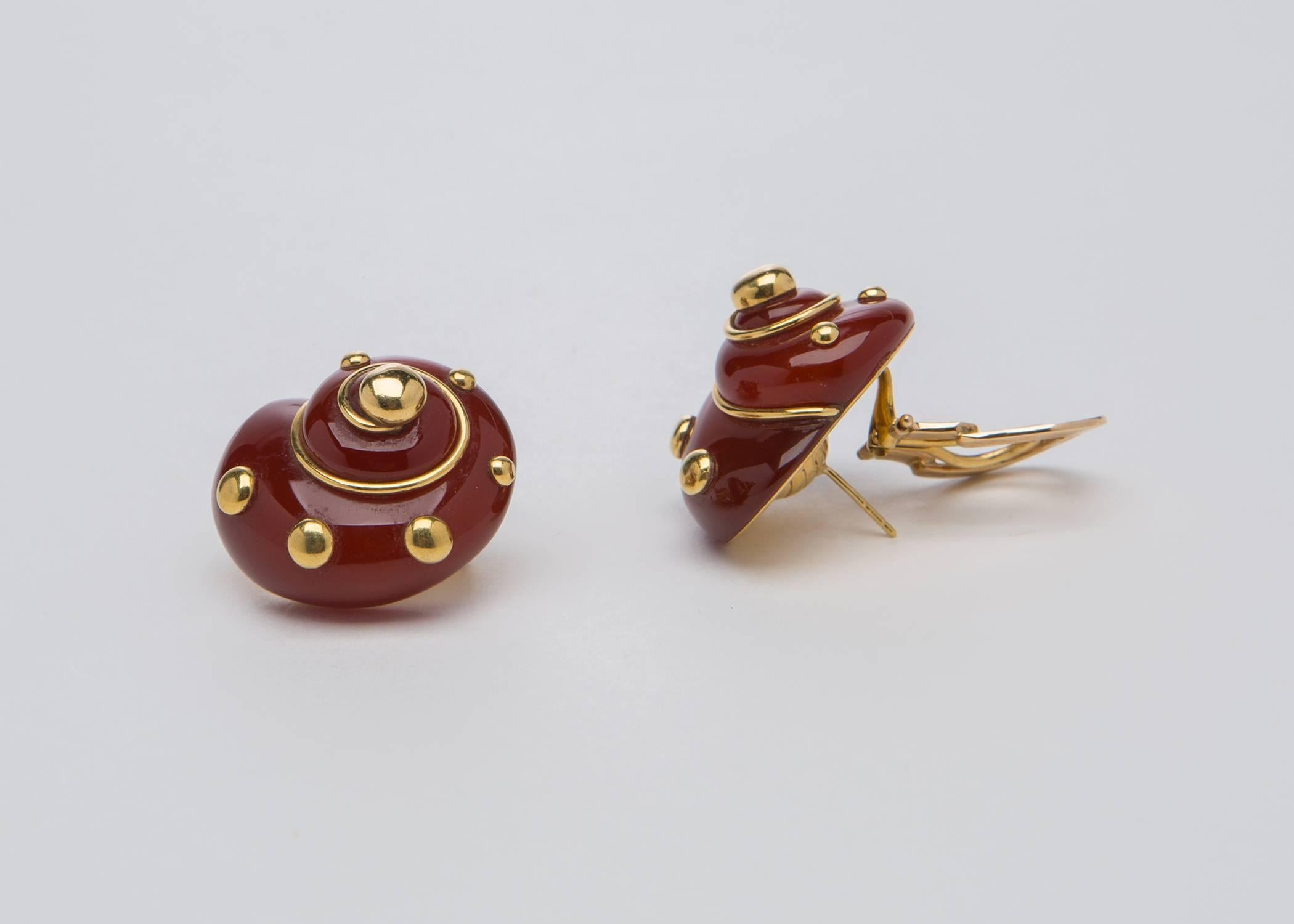 Absolutely one of Verdura's most iconic and sought after designs. Rich and saturated Carnelian is carved into a soft shell shape and finished with gold wire and ball detailing. A wearable and flattering shape. approximately 1 1/4 by 1 inch in size