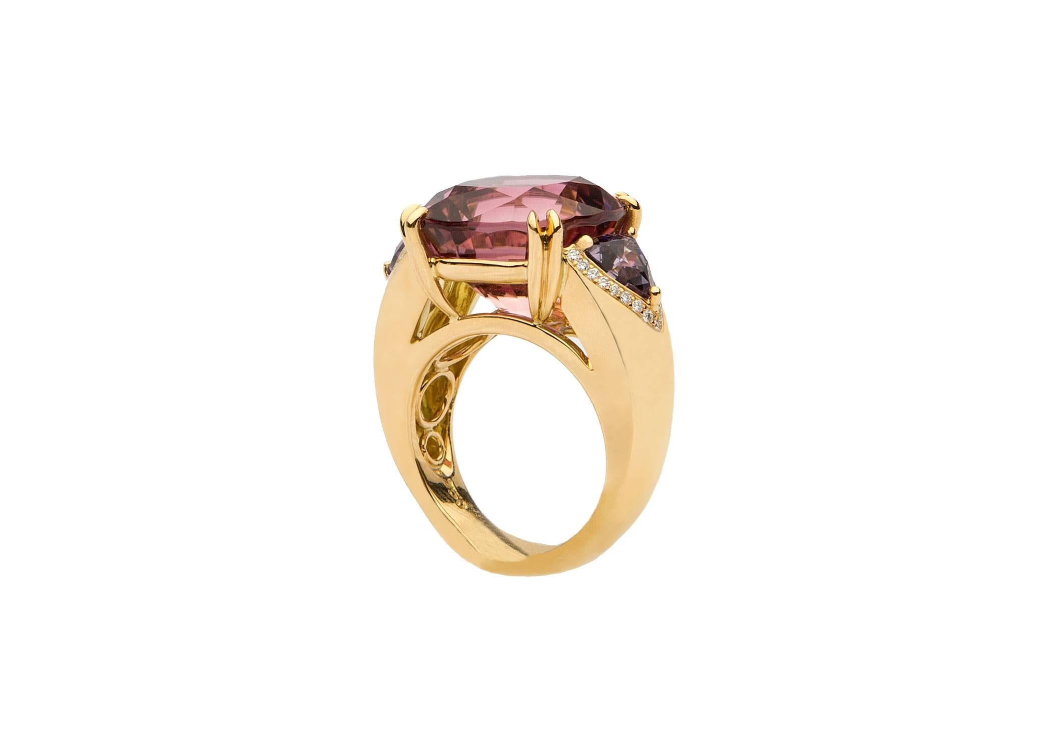 A spectacular 16.11 carat cushion cut tourmaline is flanked by a matched pair of trillion cut spinels and finished with small brilliant cut diamonds. Delicate pink and violet are a great color combination in this custom handmade David Precious Gems
