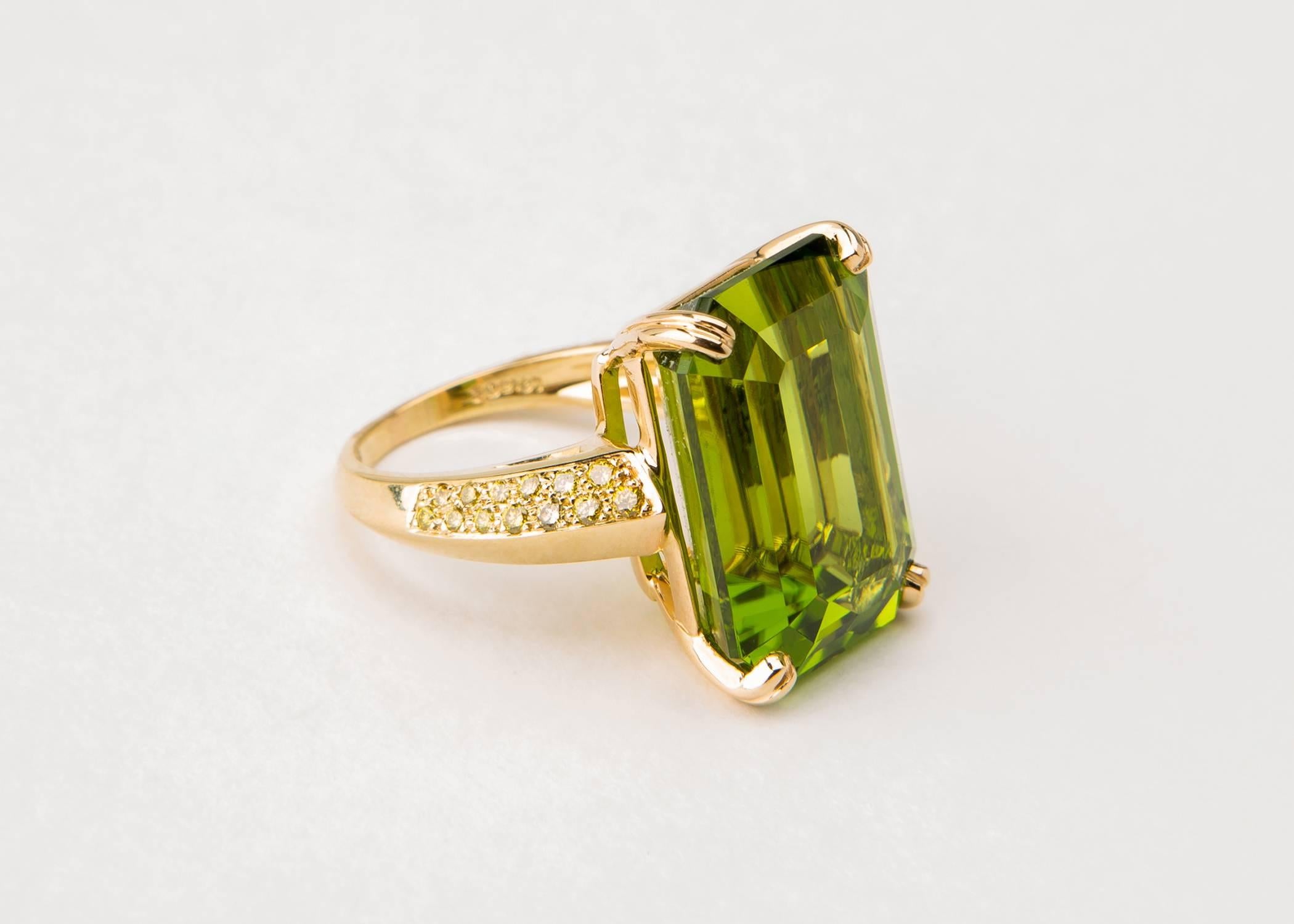 A spectacular 25 carat peridot is accented with fancy yellow diamonds in a simple geometric mounting created by Oscar Heyman. Please see additional image for mounting details.