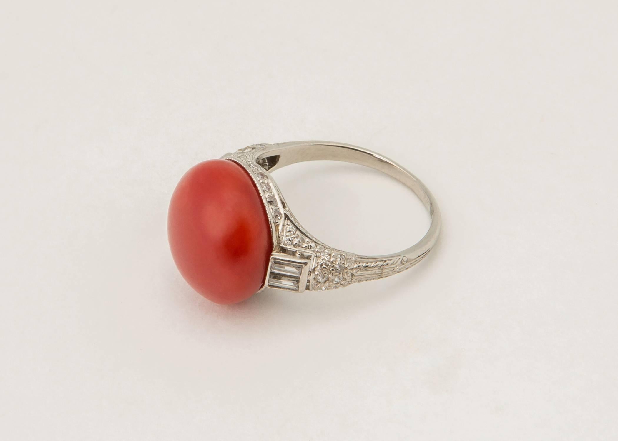 This elegant Art Deco platinum ring features a rare 13.50mm oxblood coral center. The most coveted rare color of coral. Baguette and brilliant cut diamonds are used to highlight and frame this collectable gem. Please view additional images. 