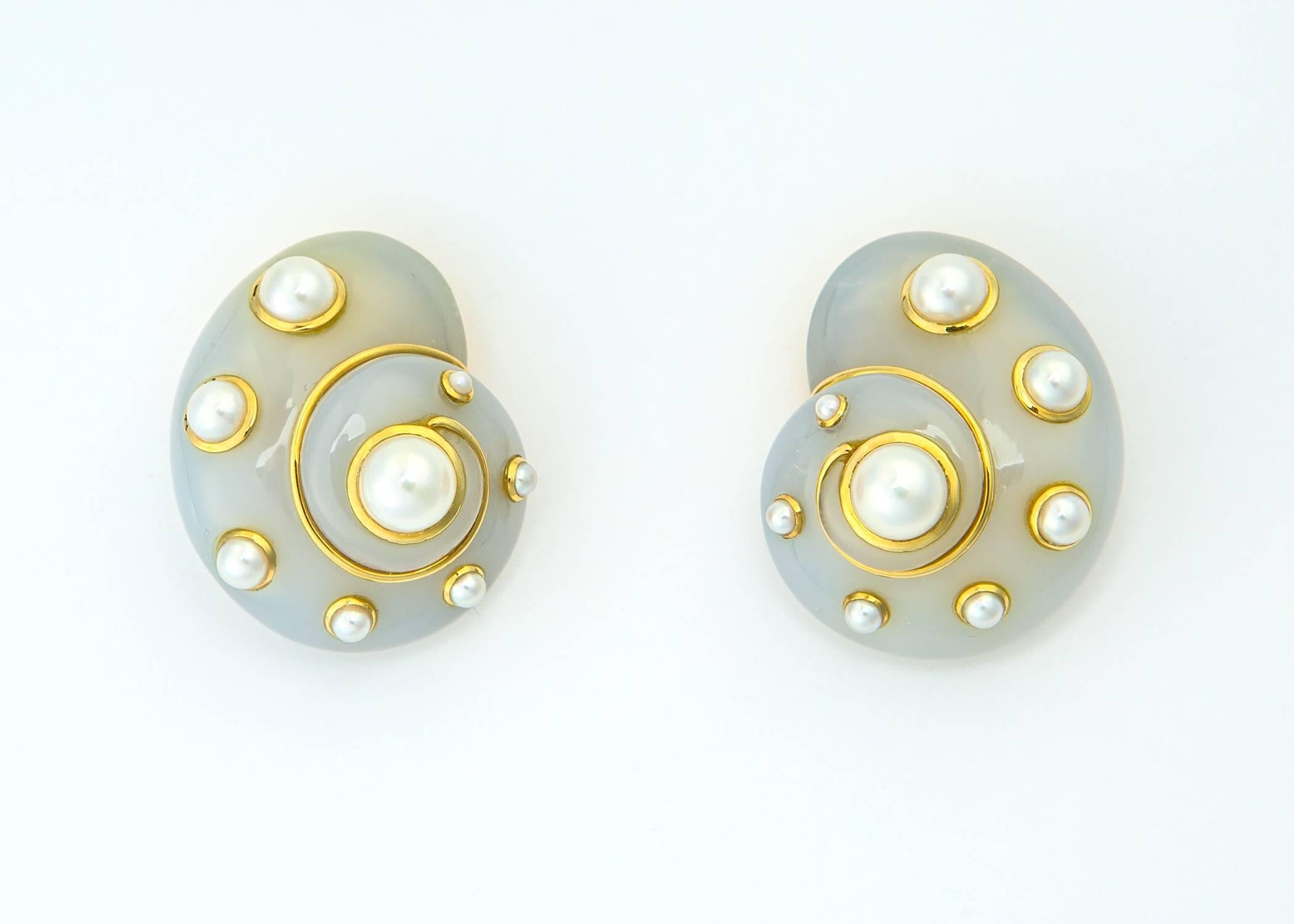 Absolutely one of Verdura's most iconic and sought after designs. Chalcedony is carved into a soft shell shape and accented with elegant pearls and rich 18k gold detailing. Approximately 1 1/4 inch by 1 inch in size with clip and poat. Simply chic