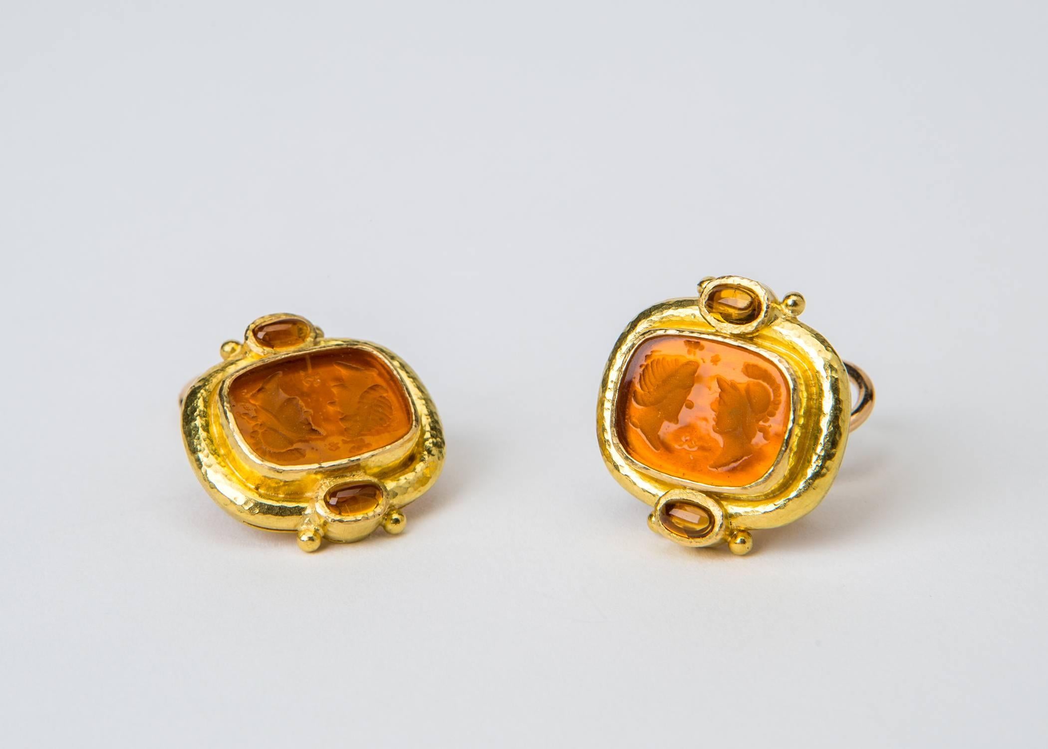 Two classic Venetian Glass intaglios in a deep orange tone are framed with rich textured gold and finished with cabochon citrine accents. Approximately 3/4 X 7/8 inches in size.