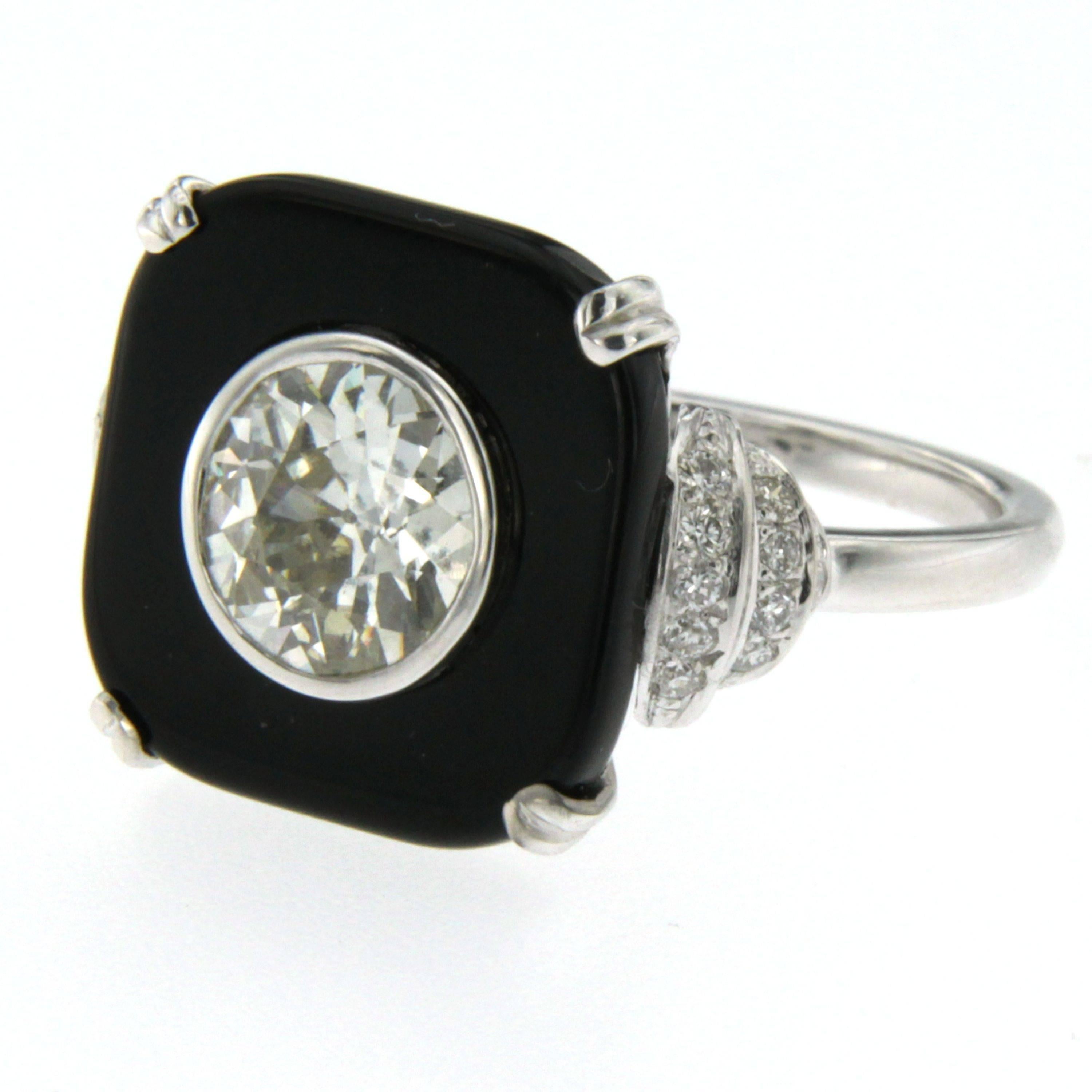 A magnificent Art Deco style 18k white Gold ring set featuring a 1.77 carat Old European-cut Diamond with a calibré-cut onyx square frame, at each side there is a geometric design set with diamonds.

Ring contains one Old mine cut Diamond