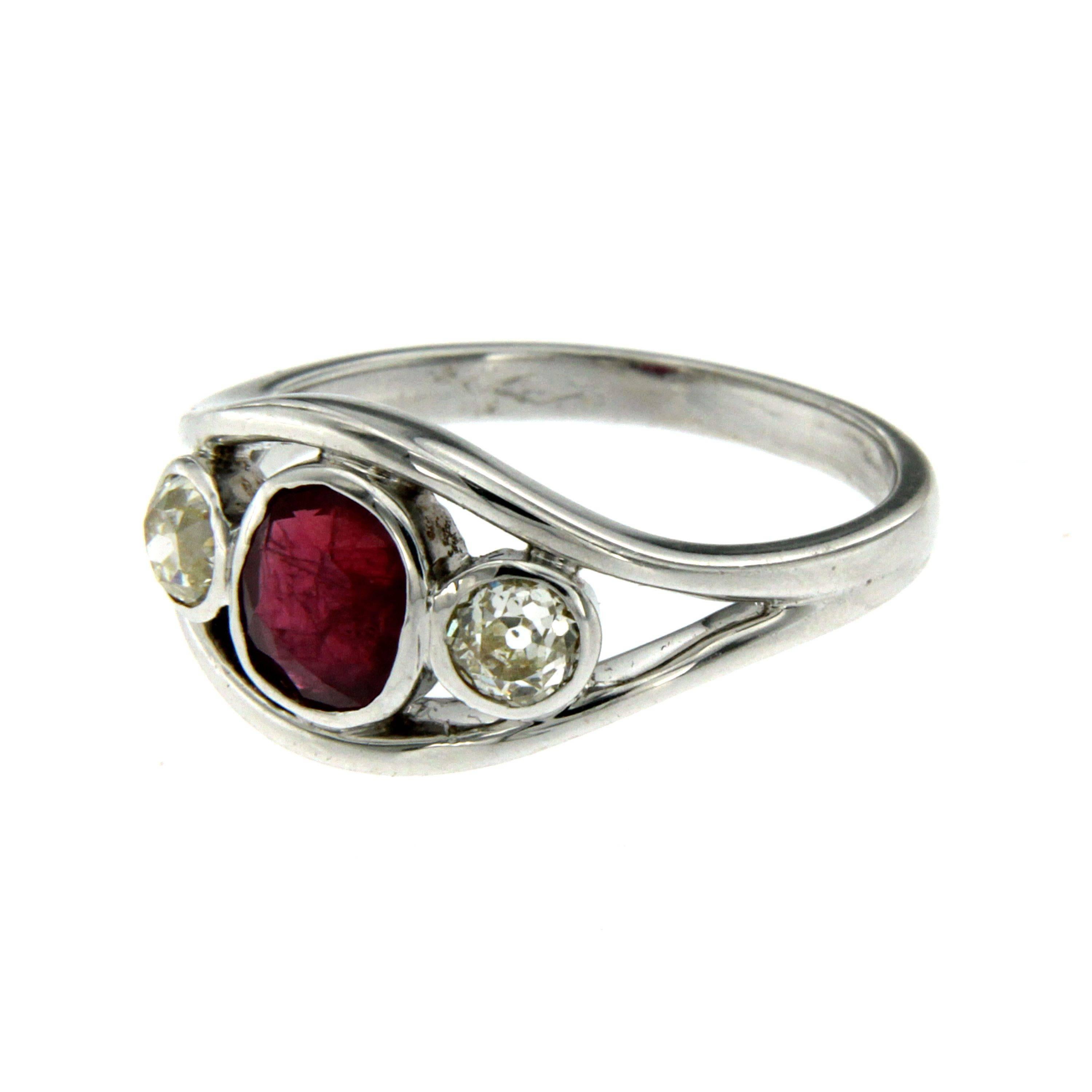Beautiful 18k white gold ring (marked 750), set with an oval cut Ruby in the center, of absolute pleasure and color, weighing 1.26 carat, at the sides there are two Sparkling European cut Diamonds of 0.25 carat each, tot. 0.50 ct graded J/K color