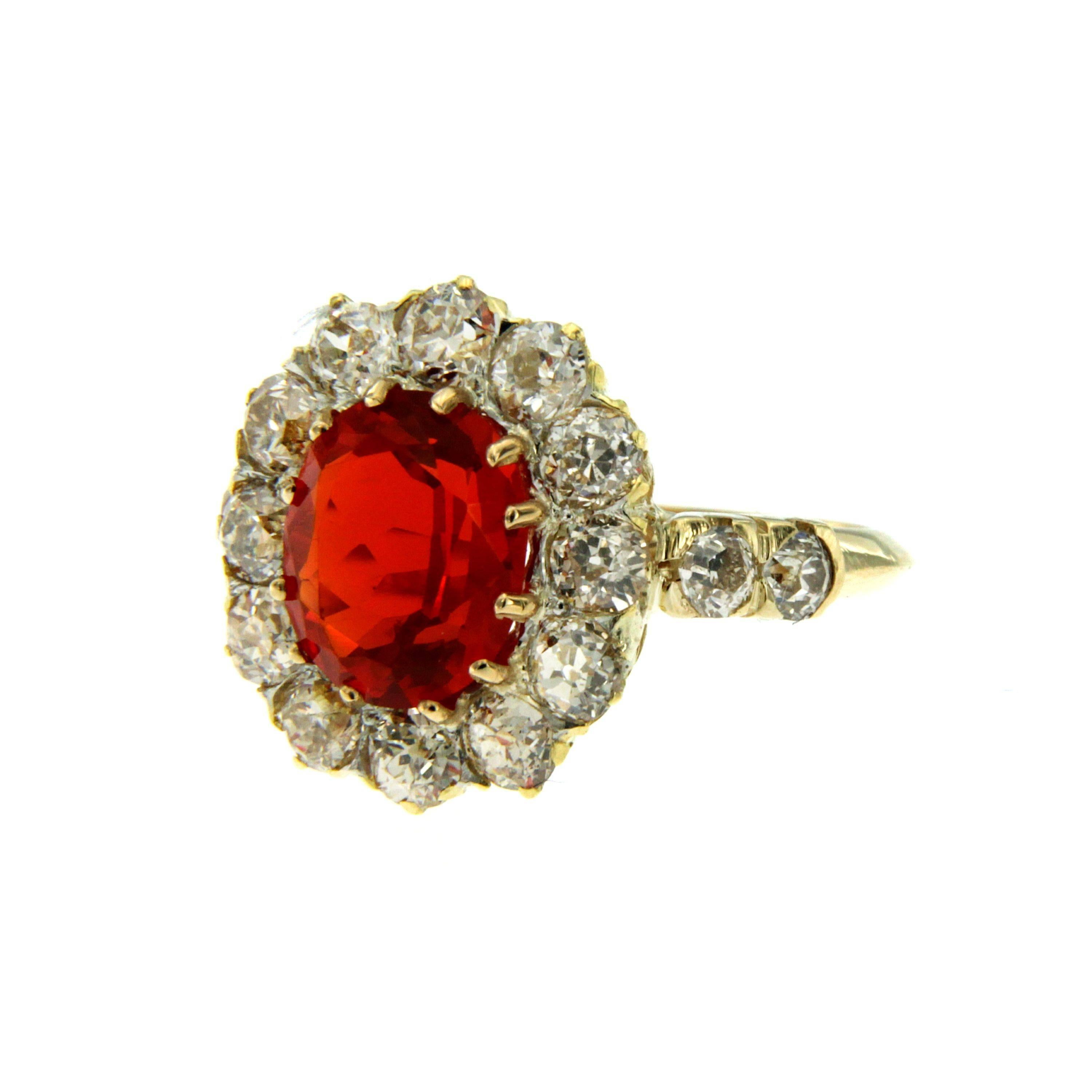 Mounted in 18k yellow gold, this cluster ring dates 1910, is set in the center with  one Fire Opal of extraordinary beauty, weighing 1.71 carat and surrounded by approx. 2.50 carat of sparkling old mine cut Diamonds graded H/I color vvs 

This