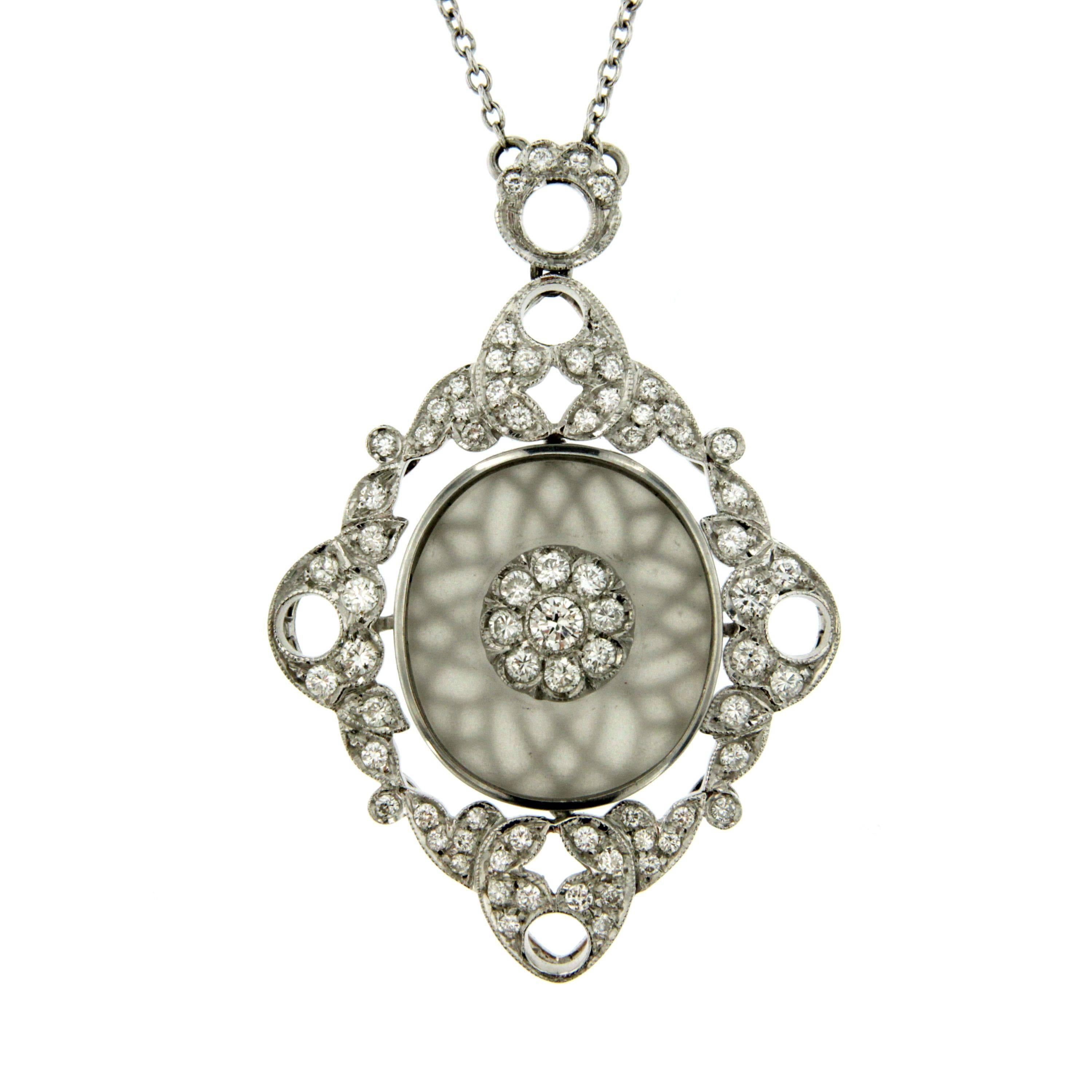 A stunning 18k white gold Art Deco pendant featuring an oval rock crystal plaque set to the center with a flower diamond motif  and framed by old european cut diamonds of estimated total weight 2.00ct, colour G clarity VVS. Circa 1930

CONDITION: