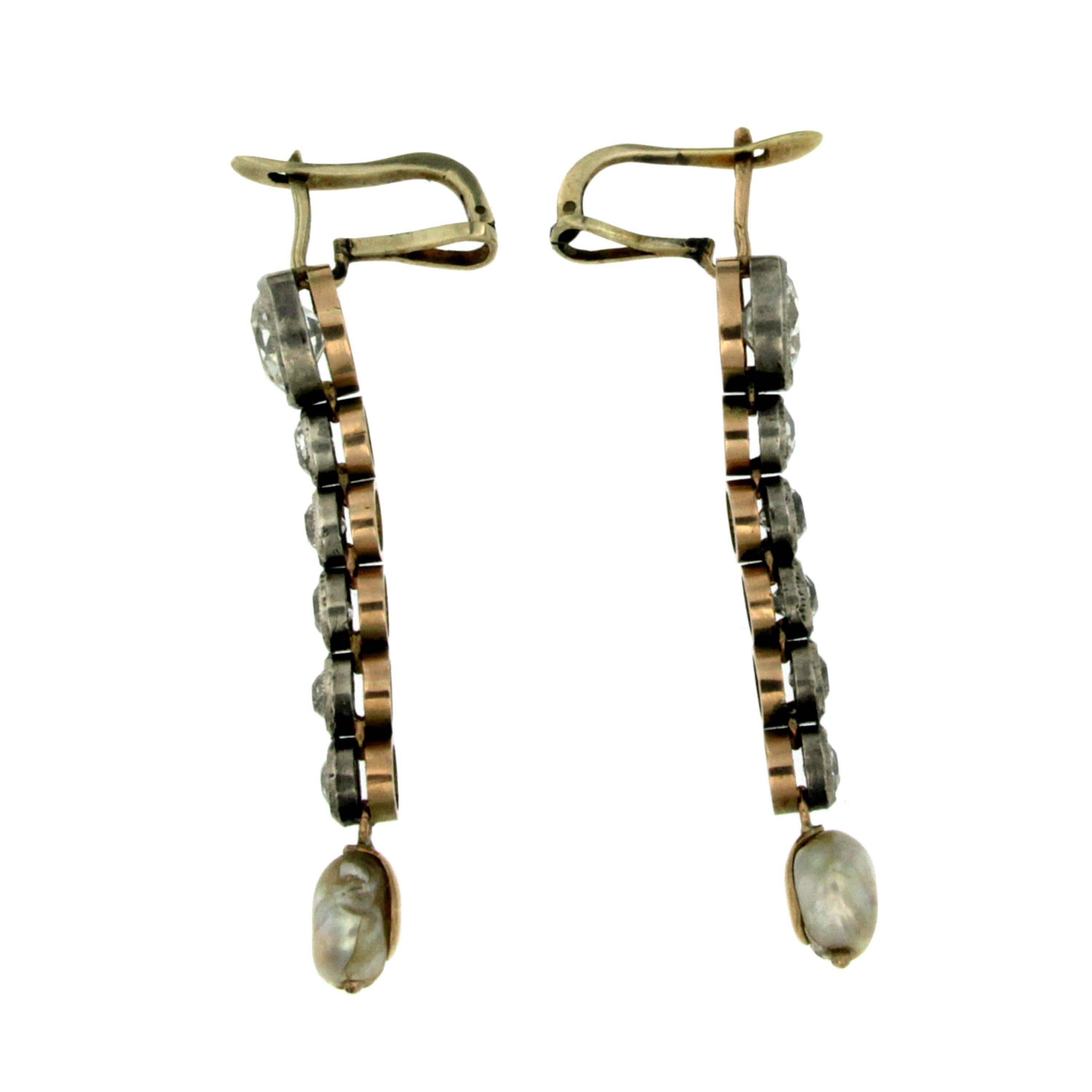 A gorgeous pair of drop earrings set in 12k gold and silver.
They are each decorated with a line of 6 old mine cut diamonds closed at their base by a natural freshwater pearl.
The 2 bigger diamonds have a total weight of 3.55 ct, and the other 10