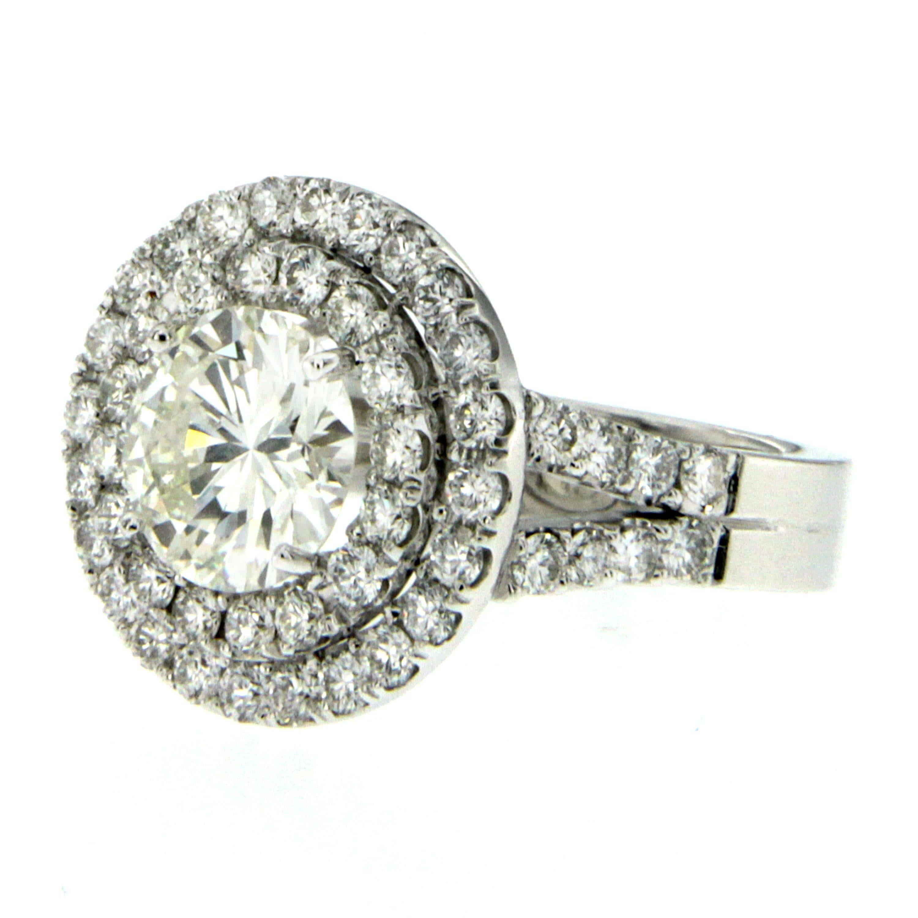 18K White Gold Engagement Ring centered with a gorgeous round brilliant cut Diamond  weighing 2.04 ct graded H color with VS1 clarity. It is set with a double diamond halo, and a diamond split shank with diamonds halfway down weighing approximately