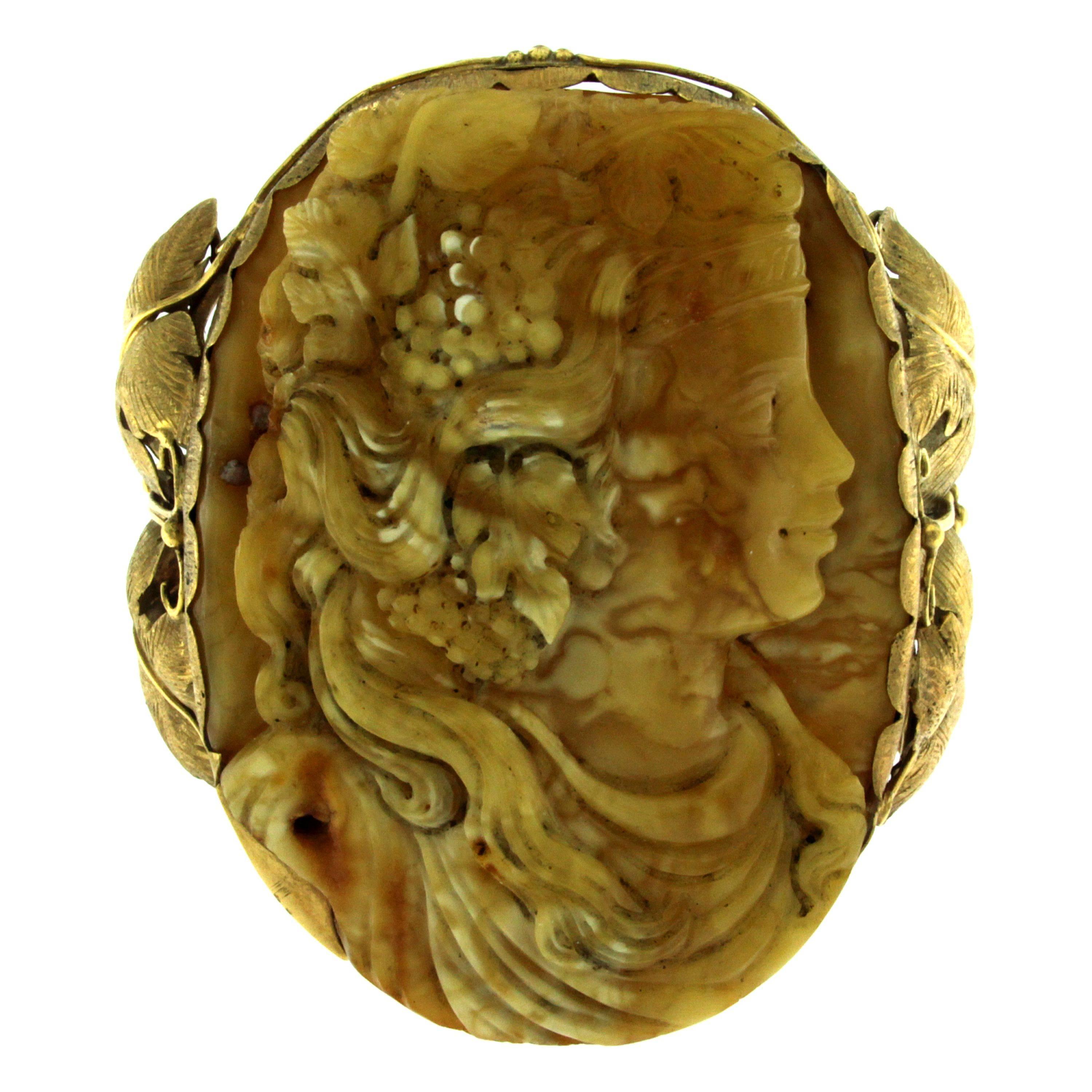 An exquisite Amber bangle bracelet handcrafted in 9 kt yellow Gold designed with a an engaging motif of a woman's face and with leaf and grape motif finely detailed. It is engraved at the edges and the joints. 
Secure catch. 
Dimensions are