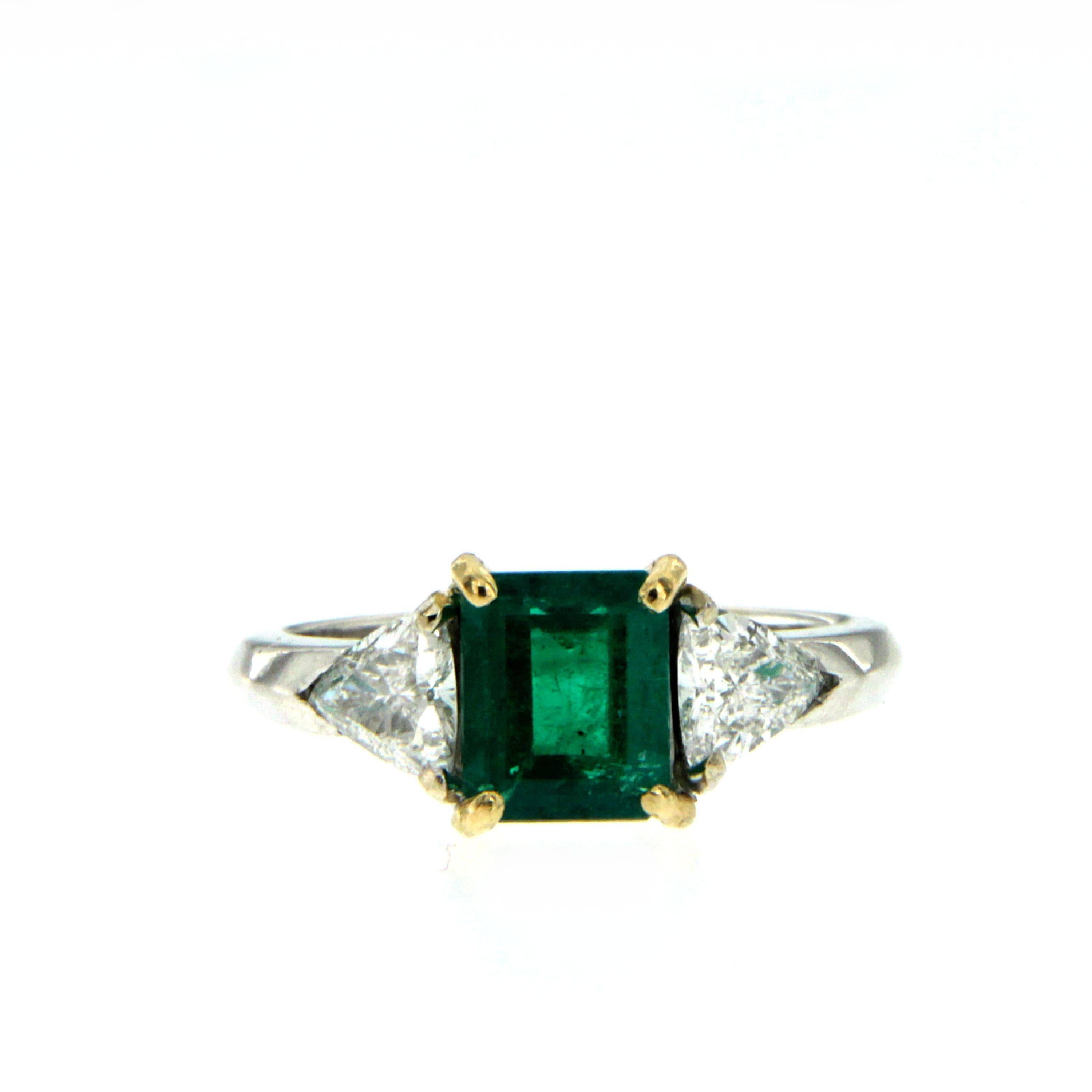 An exquisite 18k white Gold ring featuring a 1.37 ct Emerald-cut Colombian Emerald. Flanked on each side are brilliant trillion diamonds totaling 0.74 carats. The center emerald is set in yellow gold split-prongs. 

Ring Size: US 6 - IT 12 - FR 52