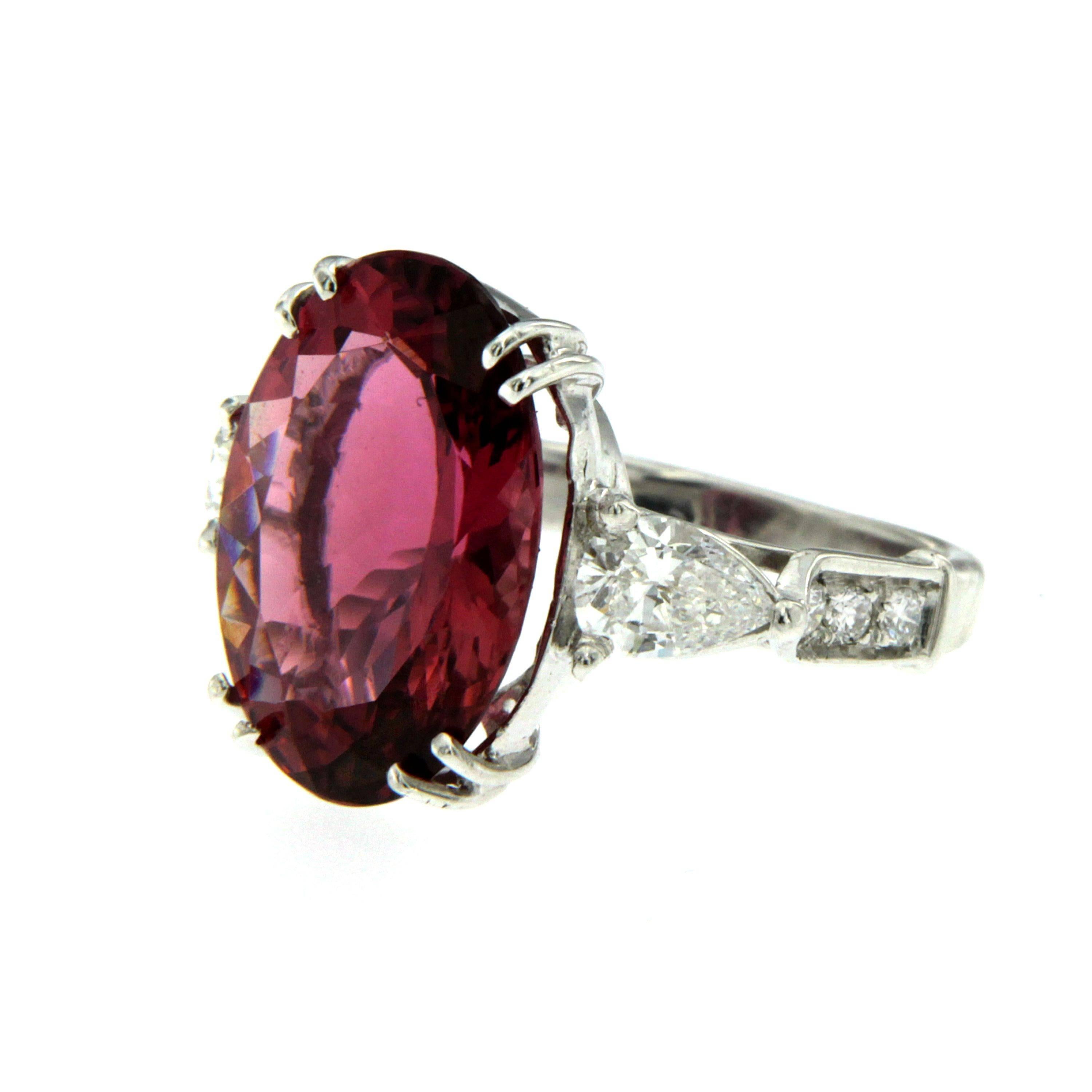 A stunning 18k white Gold ring with Rubellite Tourmaline and Diamonds. 
This beautiful ring from 1980 features a large 7.20 Carat Oval Mixed Cut Rubellite Tourmaline with a vibrant and rich color flanked by two pear cut diamond with an approx.