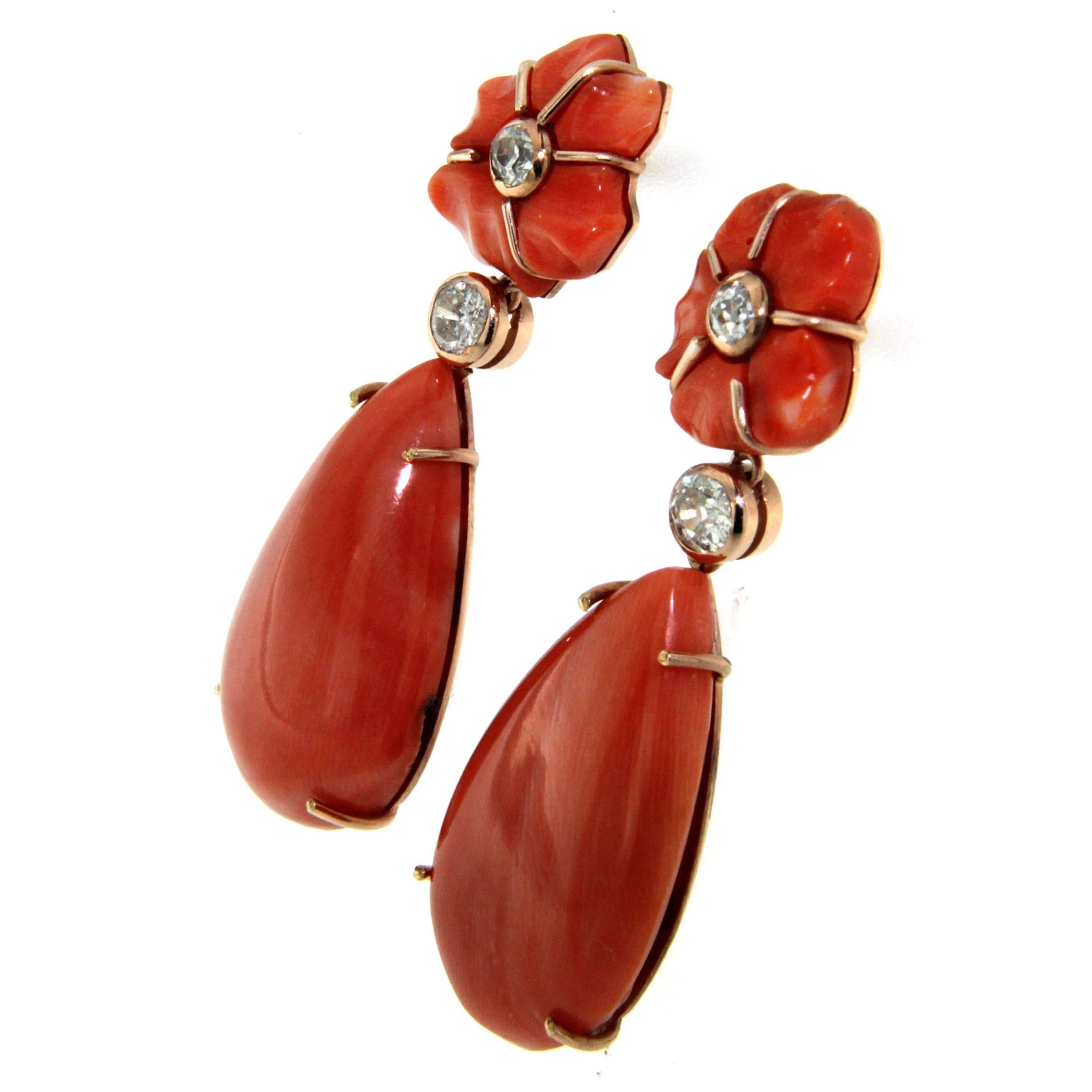 The earrings are made in 18k yellow Gold and features Rubrum Coral (mediterranean) drops and diamonds.

The floral design consists of hand carved coral petals which are set on to a back of gold. In the center a small circular gold setting holds