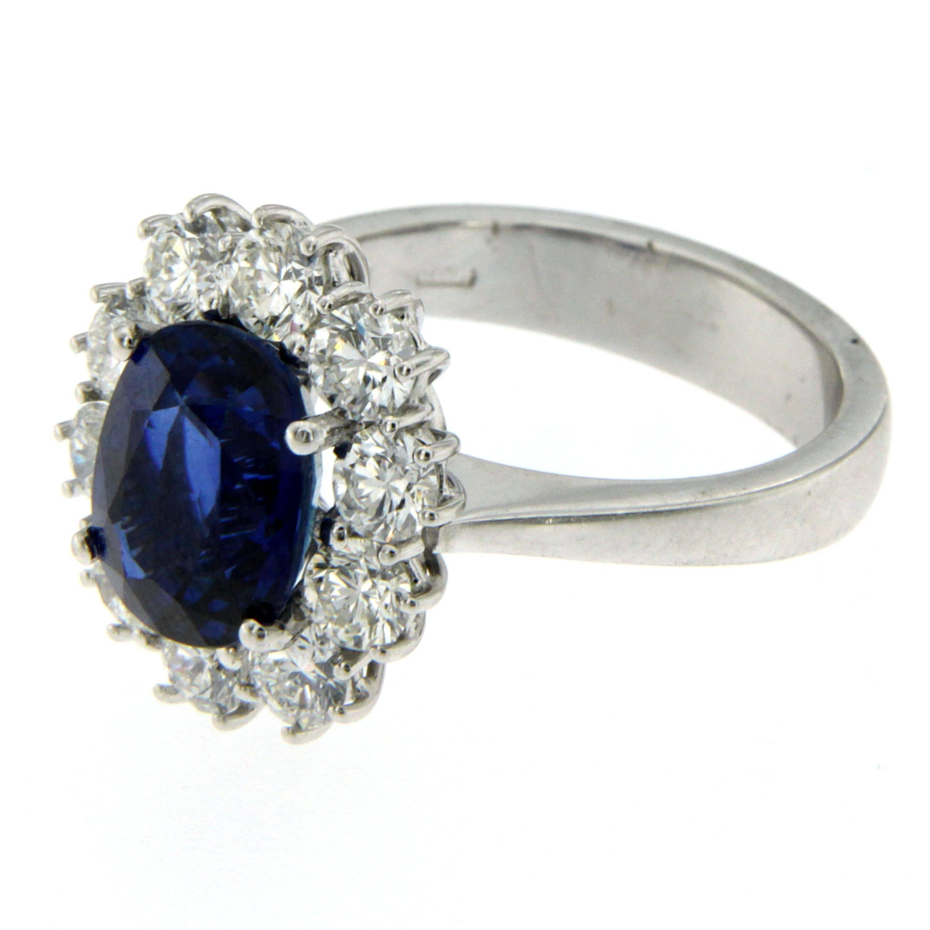 A fine and impressive 18k white Gold, Sapphire and Diamond Ring, set in the center with an oval-cut Burma Sapphire weighing 3.85 carats of extraordinary color and clarity, flanked by 10 round cut diamonds weighing 1.50 carats, clarity VvS - Color G.