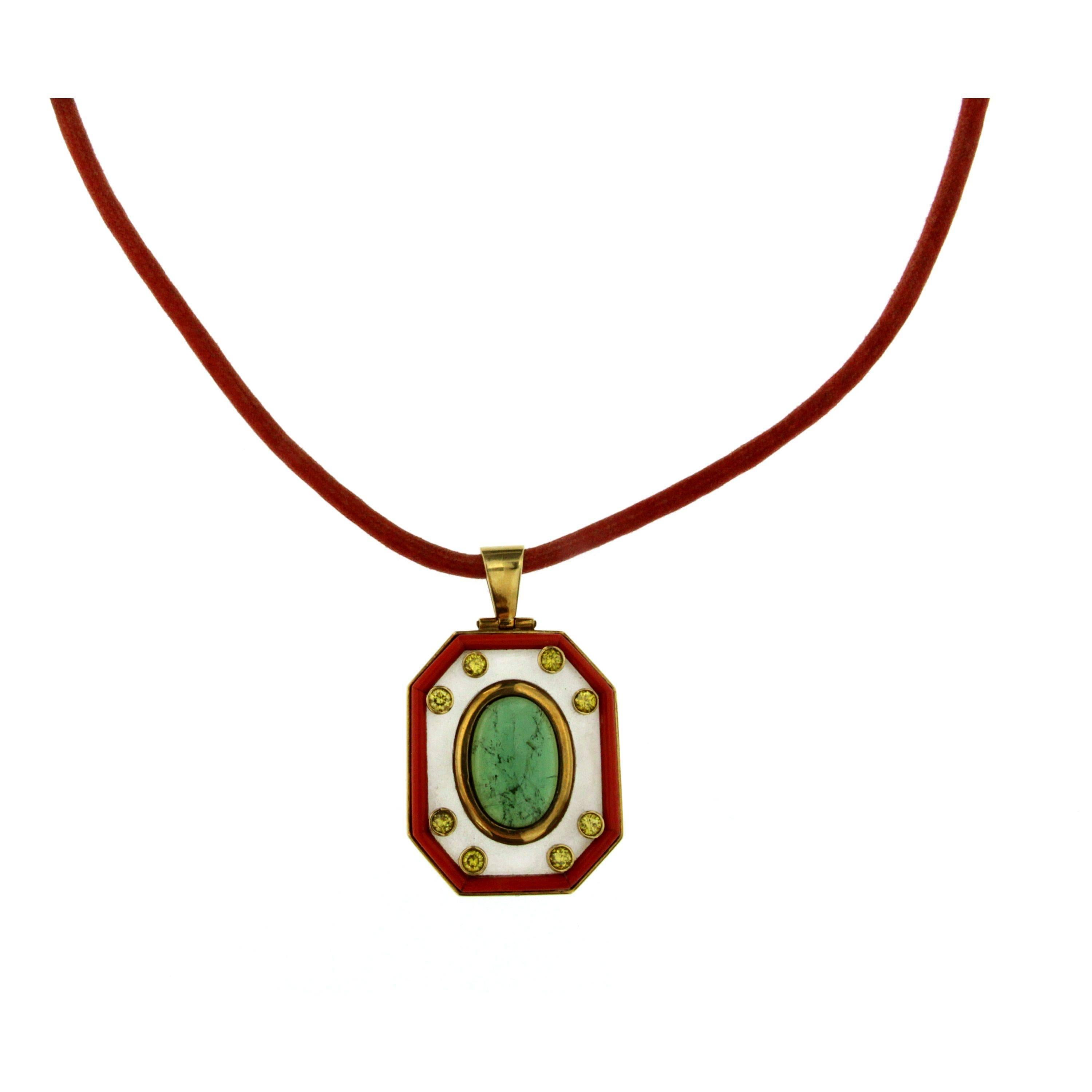 This geometric design pendant has been hand-crafted with tourmaline, diamonds, ialine quartz, coral and 18k yellow gold. 
The pendant is suspended by a 15.75 inch waxed cotton necklace cord.
Circa 1970s

CONDITION: Pre-owned - Excellent
GEM STONES: