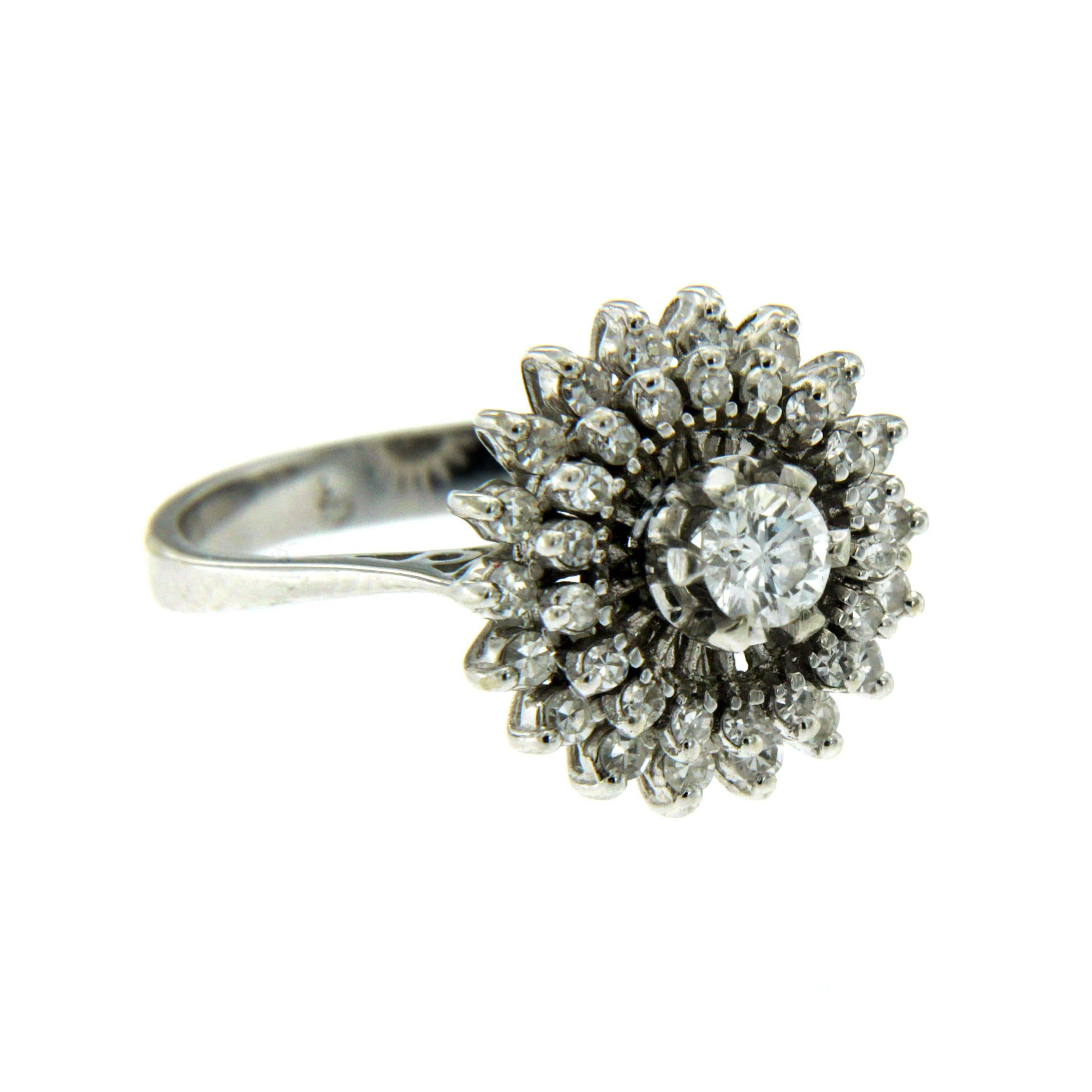 A stunning 18k white Gold ring featuring a flower design set in the center with a 0.40 ct round brilliant cut diamond framed by a double halo consisting of 0.15 carat of round brilliant cut diamonds graded F-G color and Vvs clarity. 
Circa