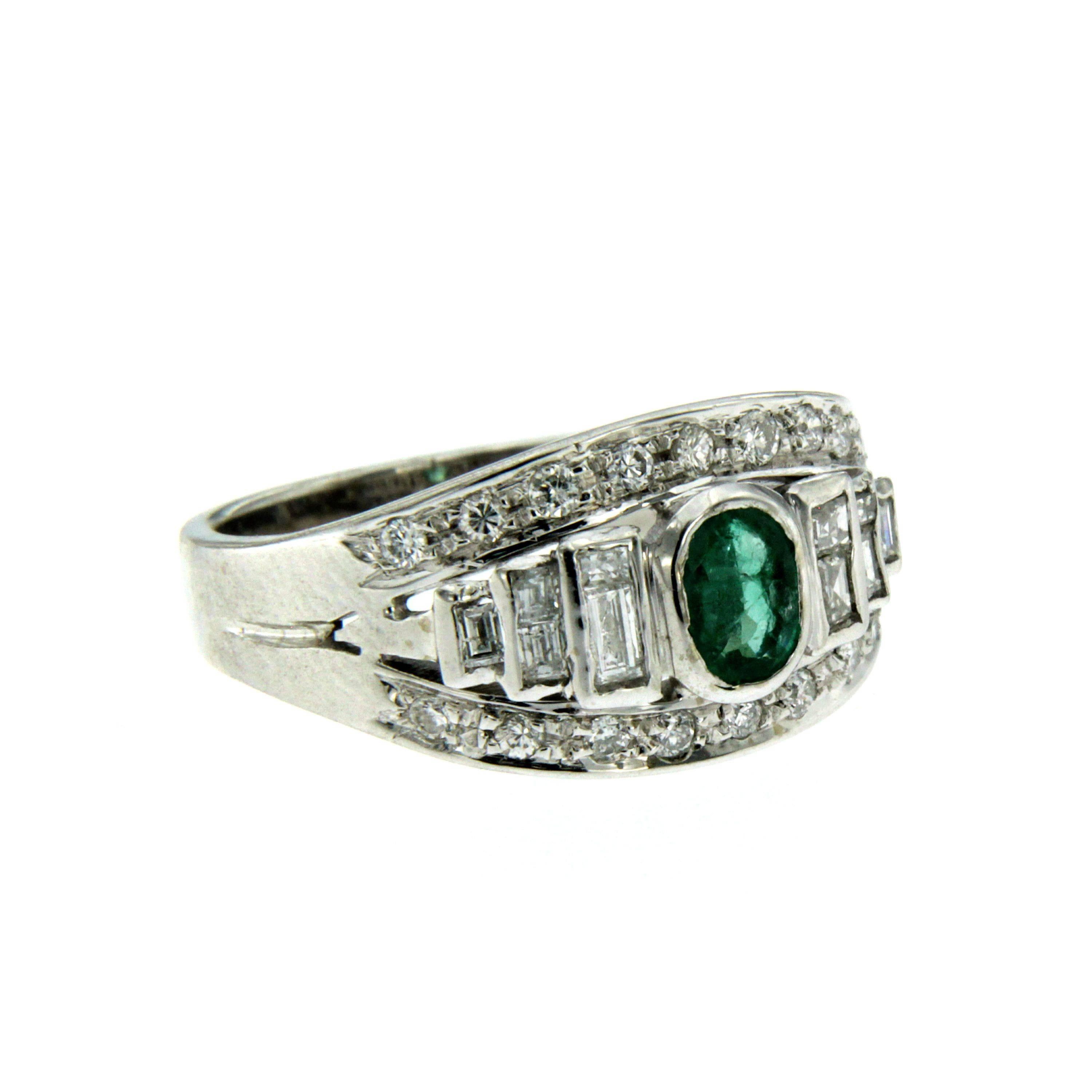 A beautiful emerald ring dated 1980, handmade in 18k white Gold showcasing an Emerald in the center  weighing approx. 0.60 carat and surrounded by 0,60 carat of baguette and round brilliant-cut diamonds graded G-H color Vs clarity.

CONDITION: