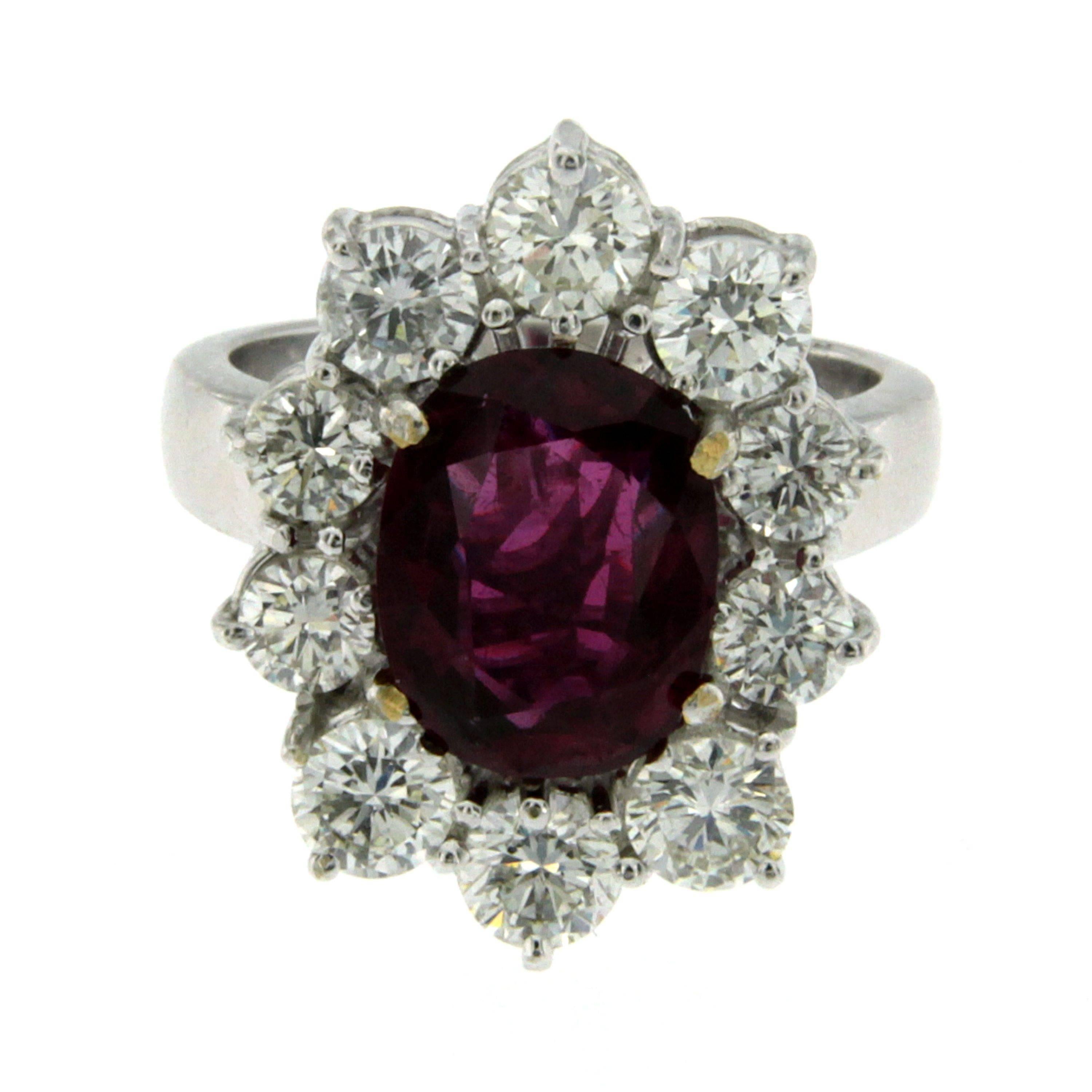 This beautiful 18k white Gold cluster ring features a 3.81 Carat oval-cut Ruby, origin Thailand, with a vibrant and rich purplish red color flanked by 10 round cut Diamonds for a total approx. weight of 3.00 carats color G  Vvs clarity.
The Ruby