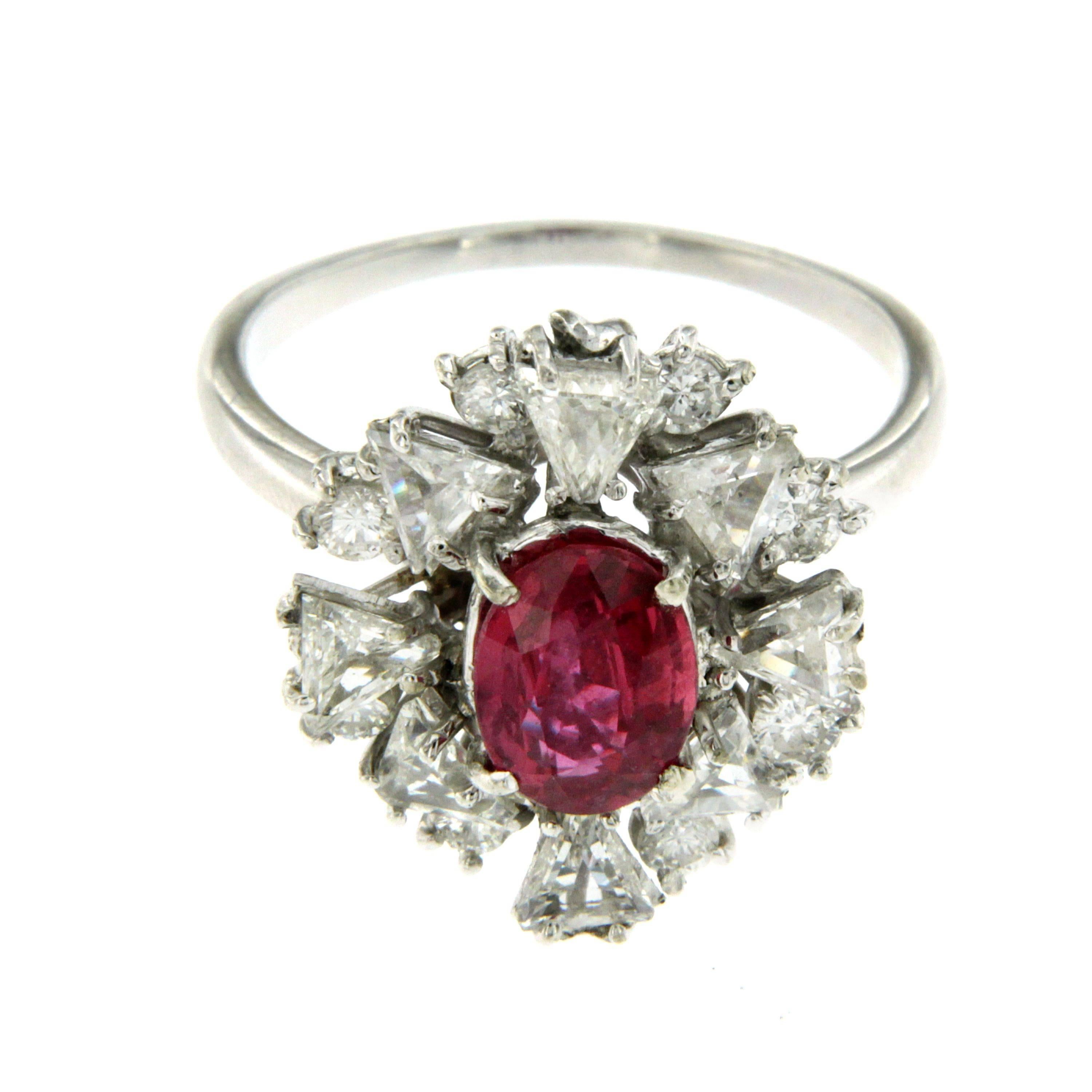 An impressive estate Italian ring set in the center with a 1.55 carat natural Ruby oval cut flanked by eight baguette cut diamonds and eight round brilliant cut diamonds. totaling 2.00 carat, graded H color Vs2 clarity.
Hand-crafted in 18k white