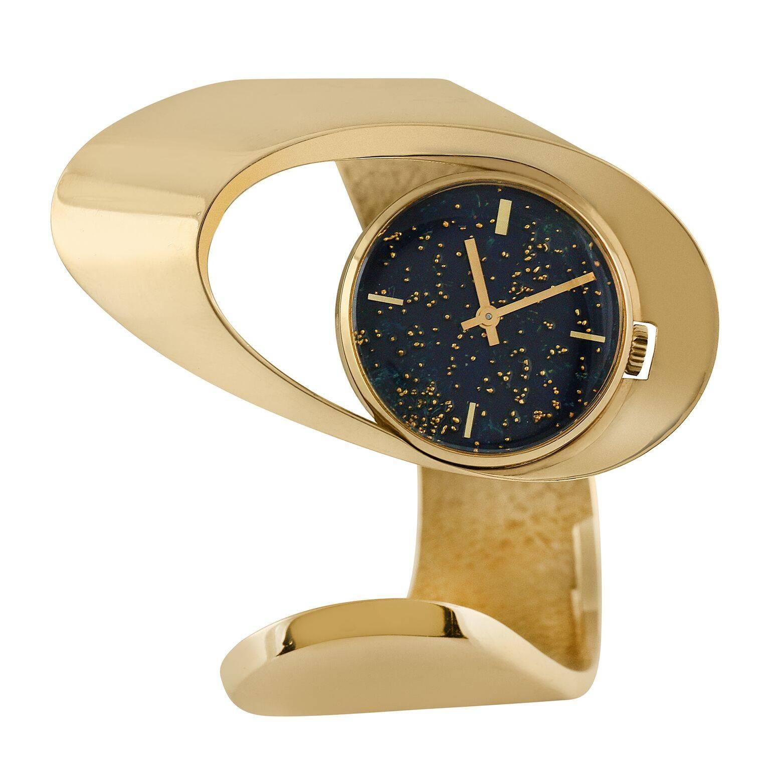 A stylish and highly modern bangle bracelet watch created by Gubelin with blue enamel astrological-themed dial. Hand-hammered 18k yellow gold textured bracelet detail. This watch is a classic modernist, space-age design. 

Mechanical Movement. 