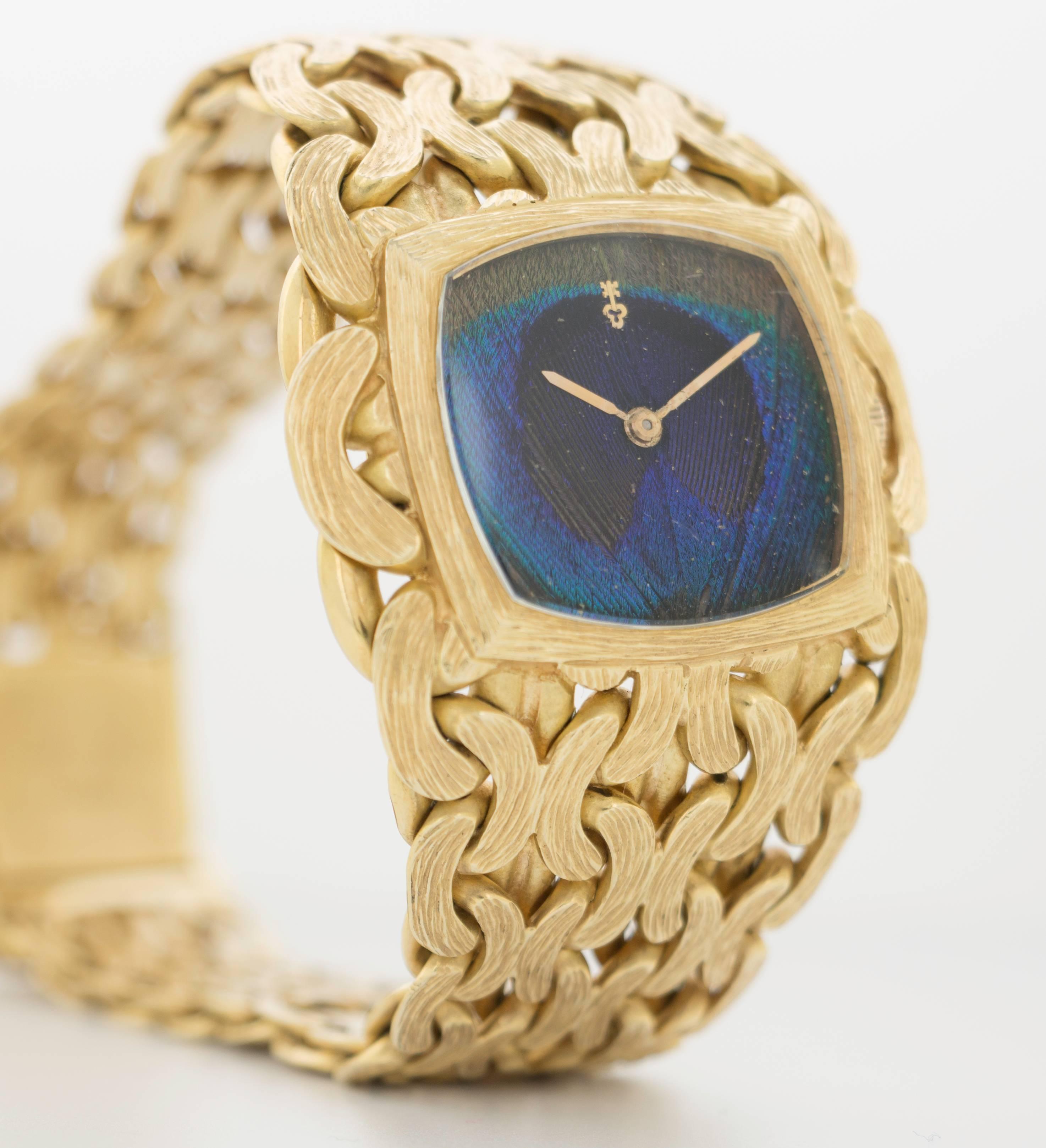 A very rare and unusual 18k Yellow Gold woven-link bracelet watch by Corum. Beyond the watch's extraordinary hand-finished textured link bracelet it has a dial composed from a Peacock feather. The dial and bracelet are in completely original