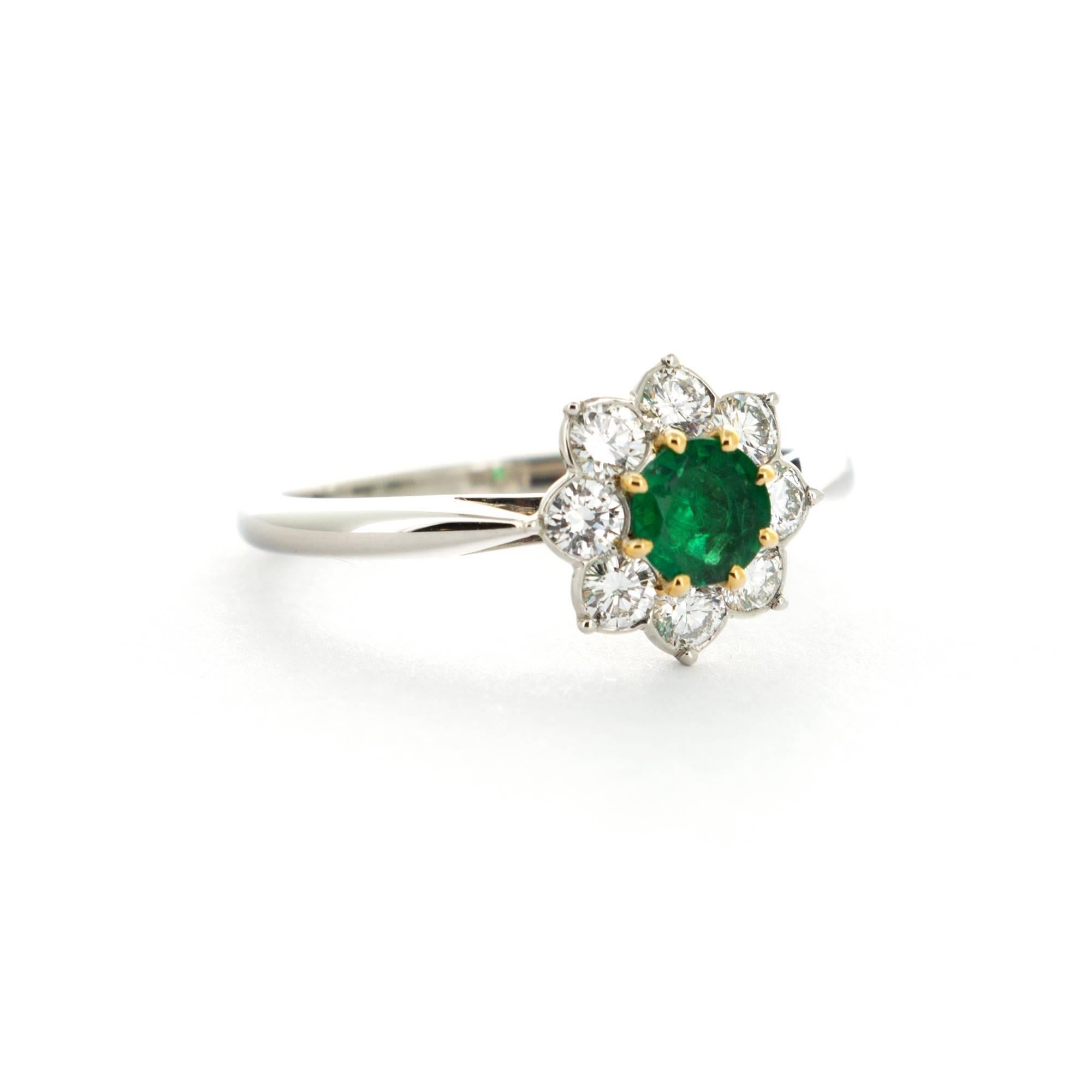 An 18k White Gold Ring with Emerald Center Stone and Pave Diamond Surroundings by Cartier. Made in France. Size 6.25. Can be resized upon request. 