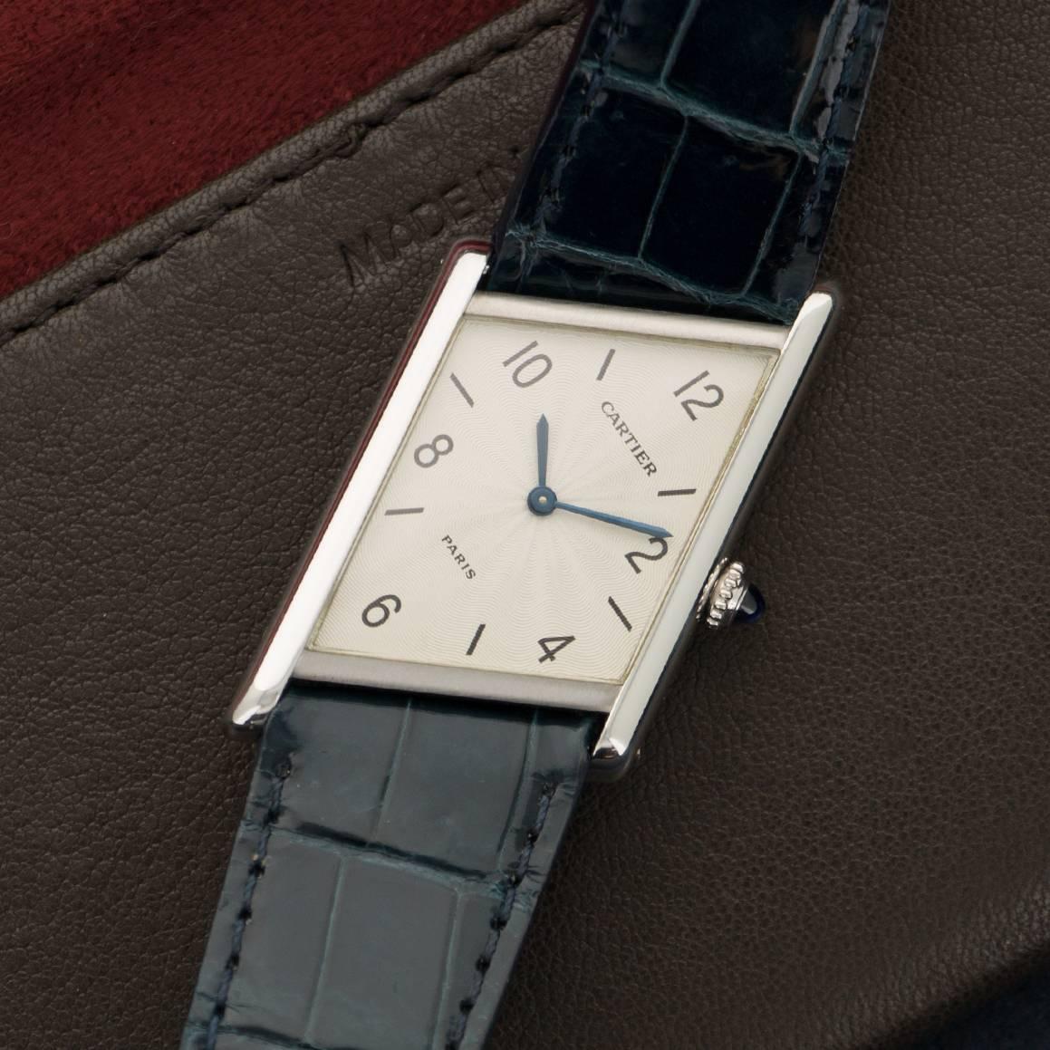 A Platinum Asymmetric Tank Watch by Cartier. Model Number 1996. Limited to 100 Pieces. Case measures 25mm X 34mm. Comes in its original box. 