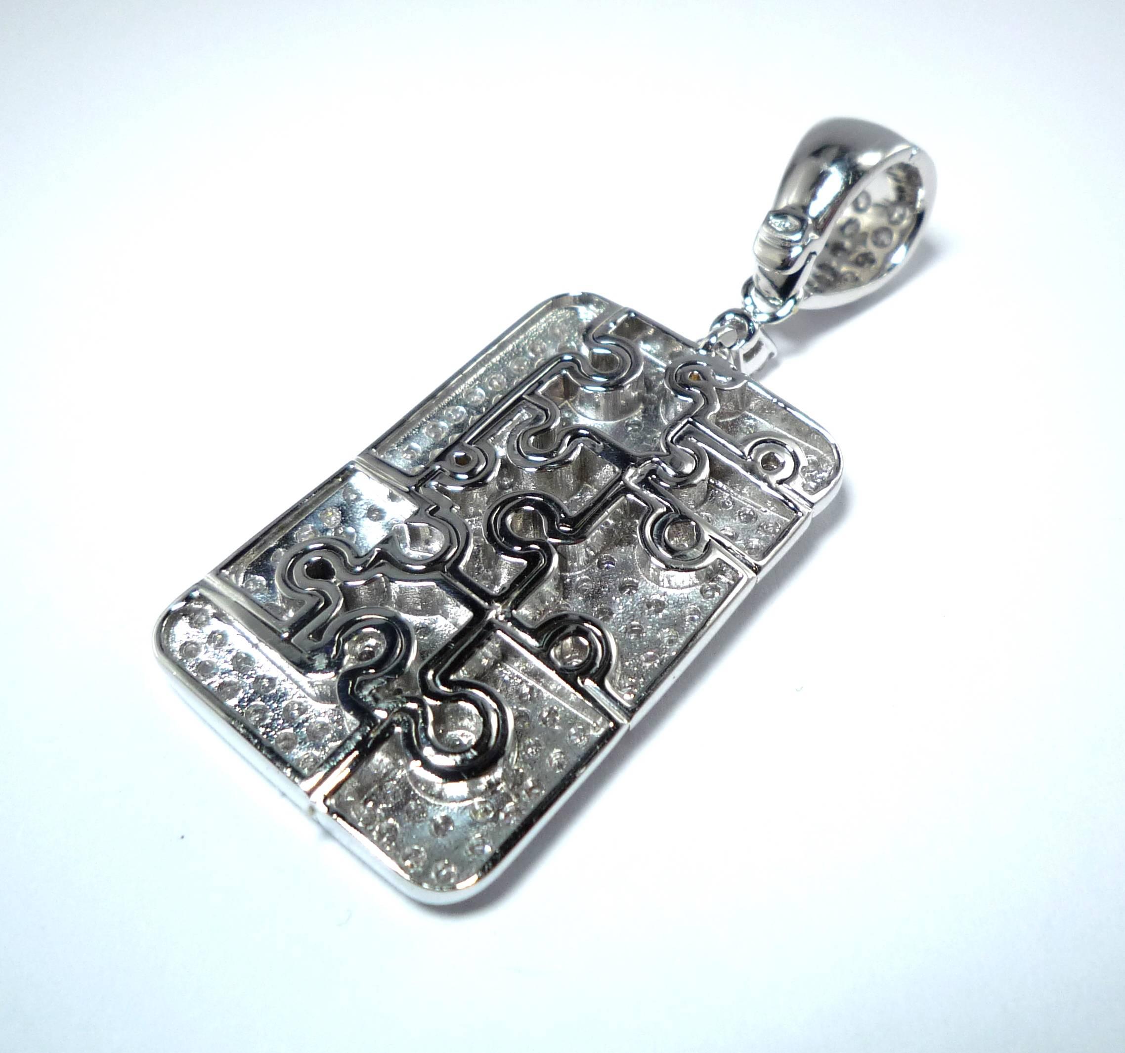 Pendant with engraved jigsaw pieces set with Diamonds, 2.32 carats, 
mounted in 750/-White Gold, movable closure.