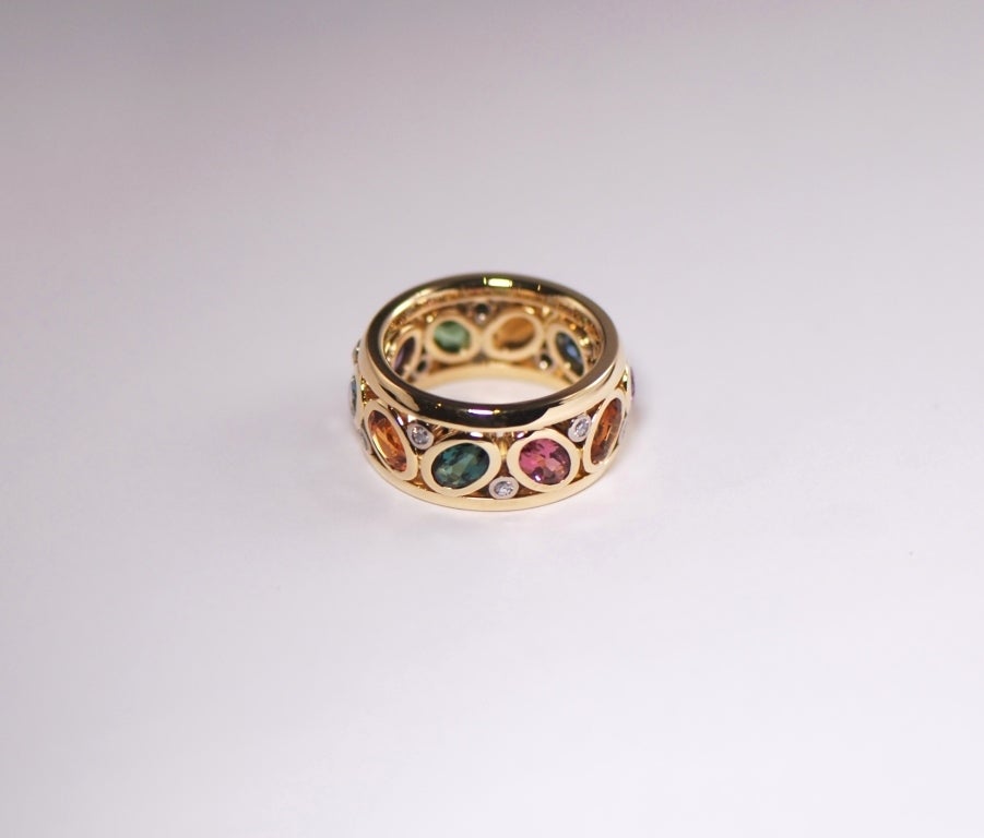 This reinterpretation of a classic eternity band ring 
is made with variegated gemstones. 
The 10 gemstones, approx. 5,09 ct., 
(1 Tsavorite, 2 Citrine, 2 Aquamarin, 1 Rodolith, 
1 Mandarin Garnet, 1 green Tourmaline, 1 pink Tourmalin) 
are