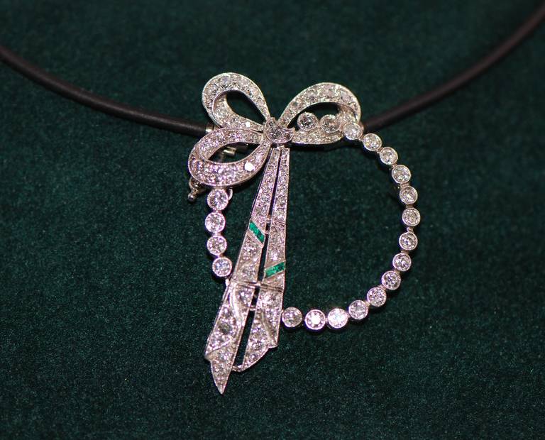 ART DECO Diamond Pendant, 
modernized from a brooch to a pendant with a bayonet catch, 
mounted in Platinum with
Diamonds, approx. 1.5 ct., and
2 Emeralds, milgrain setting, 
on the rear side with a bayonet catch suitable
to the natural rubber