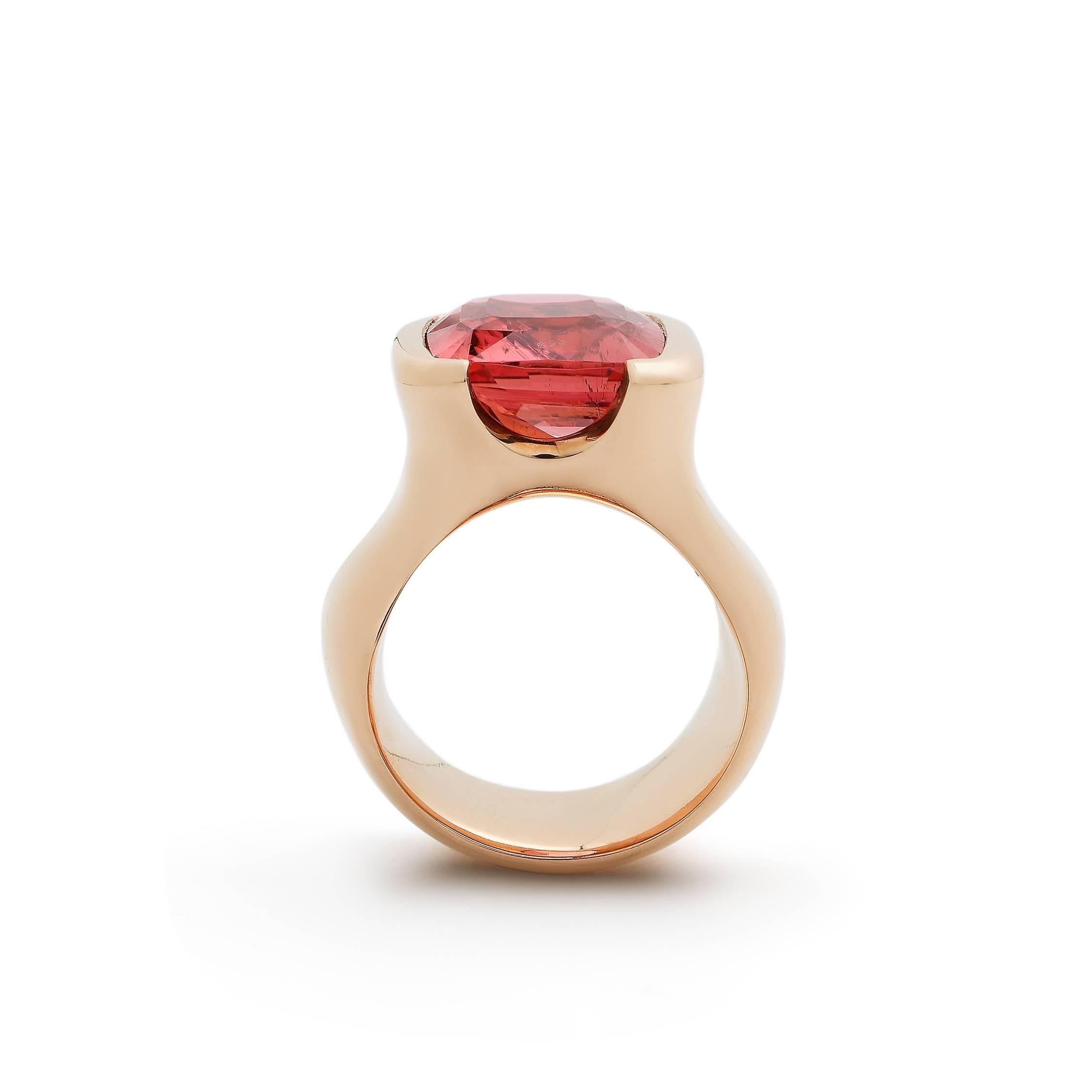 18 K rose gold ring set wit a 9,90 ct deep pink tourmaline.
The stone is 14.6 mm (length) x 16.3 mm (width, includes the gold rim). The height of the stone and setting is 9.9 mm.
The widest part of the shank is 16.5 mm and at the base the shank