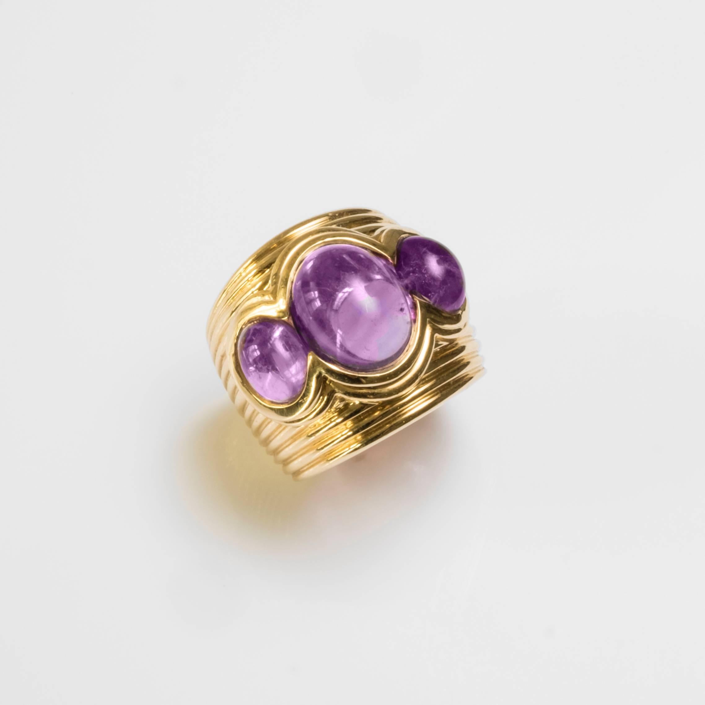 Ring composed of 18k gold and three amethysts - a large amethyst in the center and two smaller ones on each side. The band of the ring is encompassed with several ridges. 

Ring size : 50 EU / 5 1/4 US
