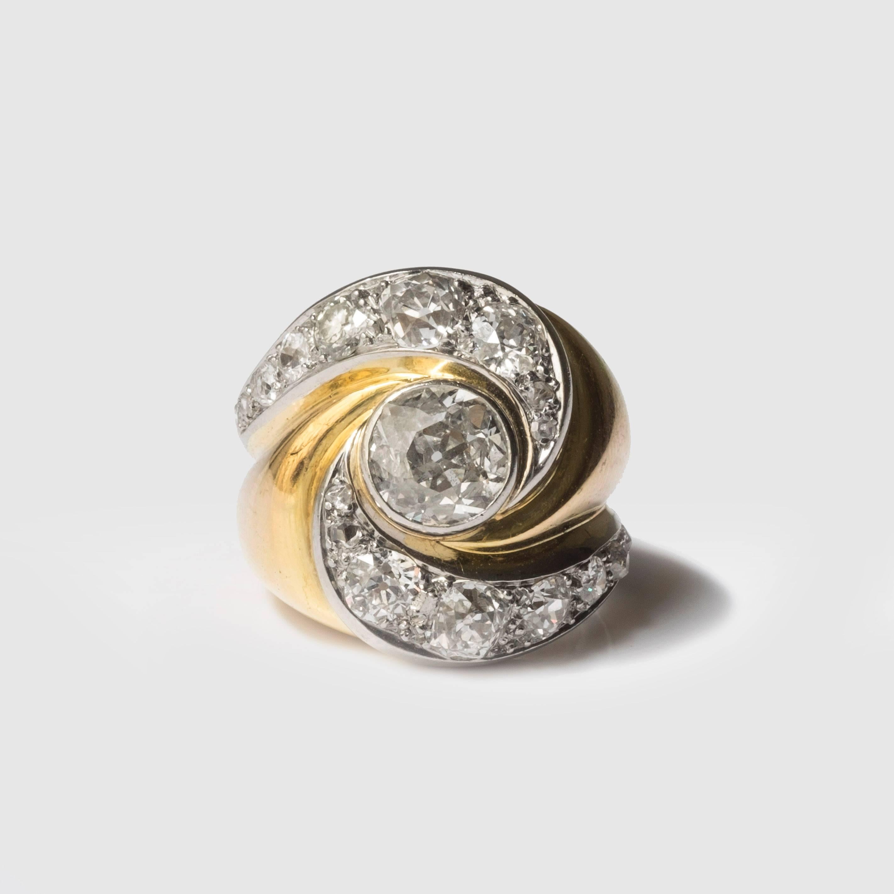 Ring aus Gold und Platin von Suzanne Belperron. Dieser bezaubernde Ring ist mit einem Diamantpavé-Wirbelmotiv verziert, das sich um einen Diamanten im Altschliff dreht. Es enthält französische Prüfzeichen. Olivier Baroin bescheinigt, dass dieser