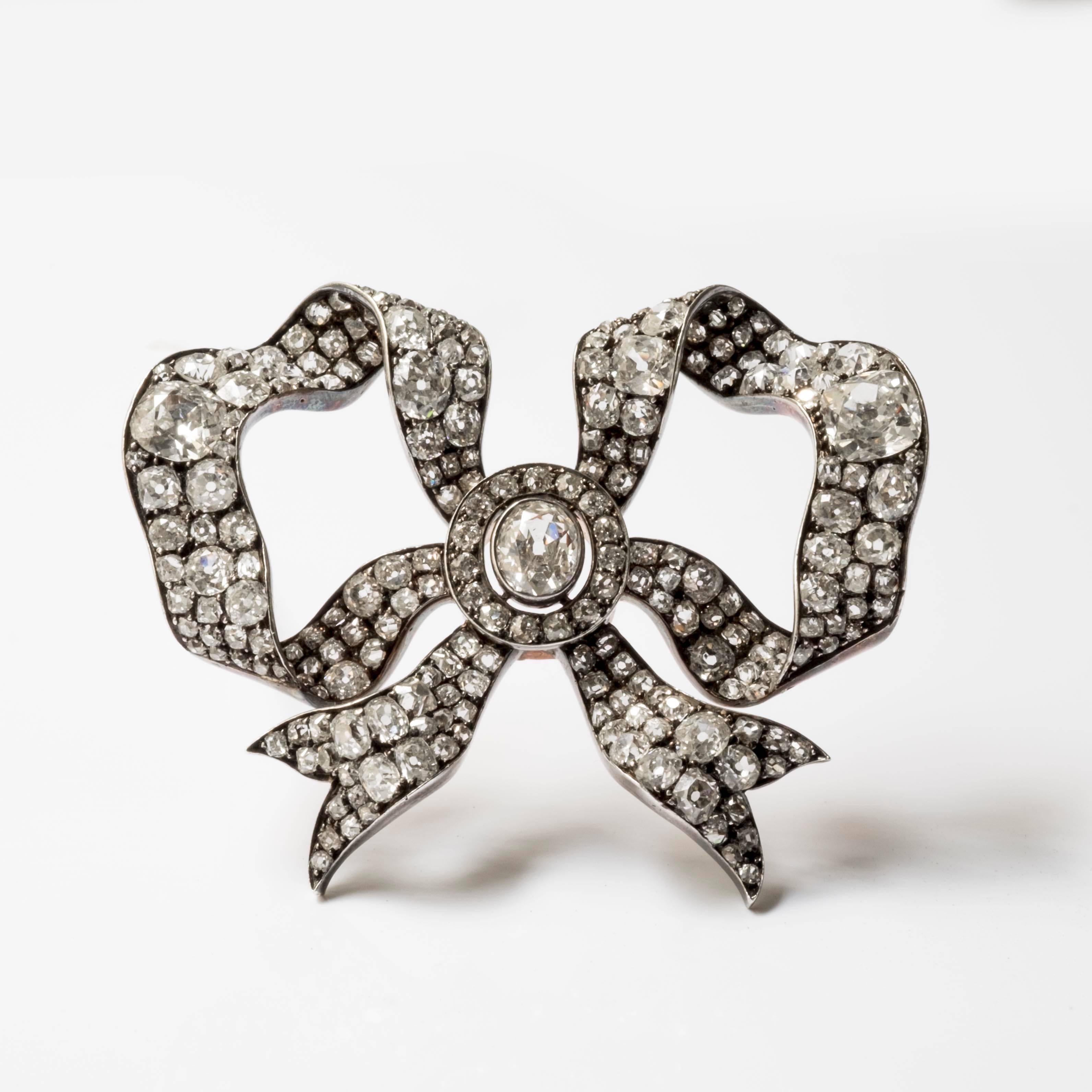 An antique bow-shaped brooch composed of gold, silver and old cut diamonds set in grains. This desirable and dainty brooch was manufactured in the 1880s. The 3 main stones weigh approximately 2 to 3 carats. These jewels were made for the french