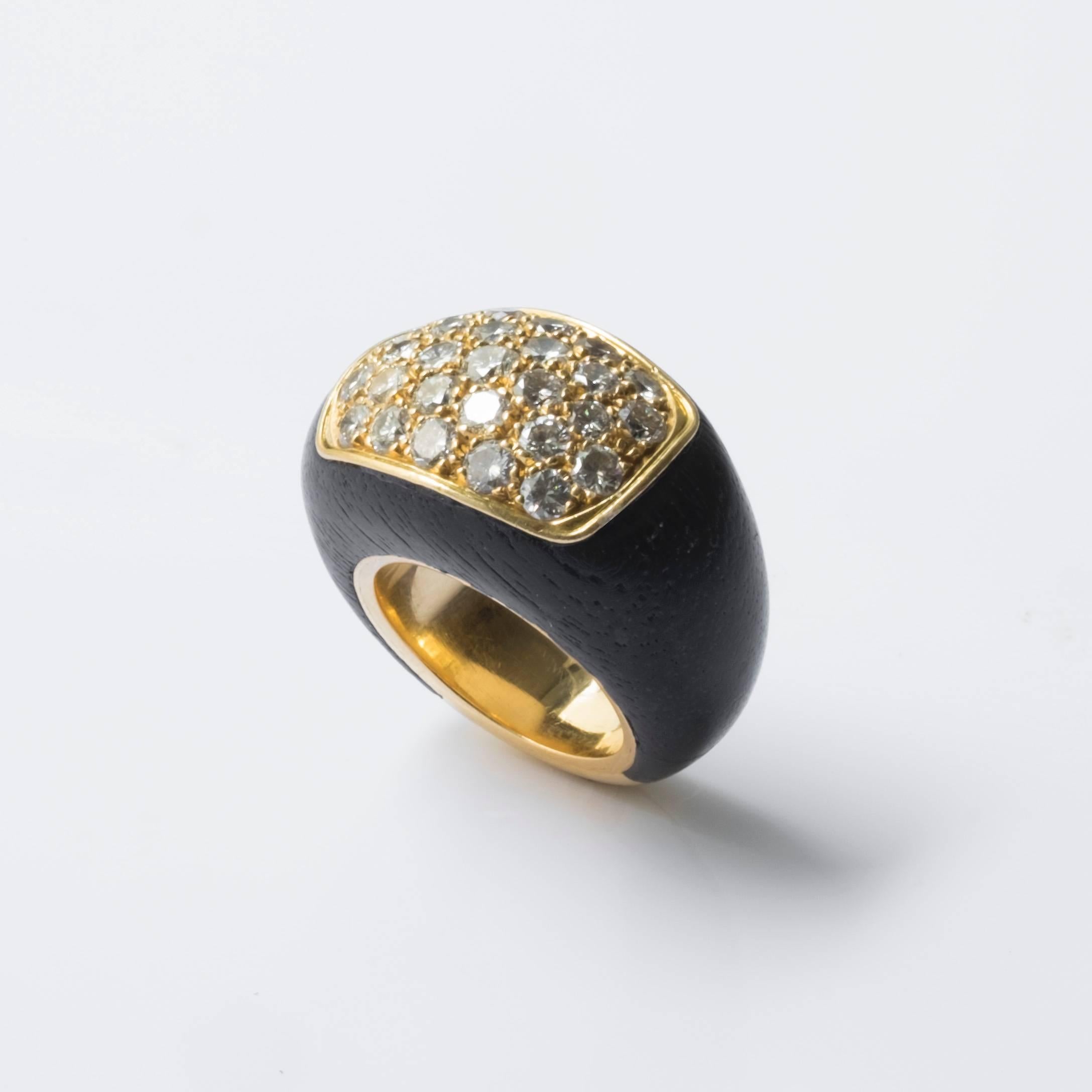 Ravishing ring by Rene Boivin composed of 18 karat gold, wood and diamonds. The ring is embellished with radiant diamonds set in grains, forming a circle at it’s center, and 18 karat gold surrounding the circumference of the circle. The rest of the